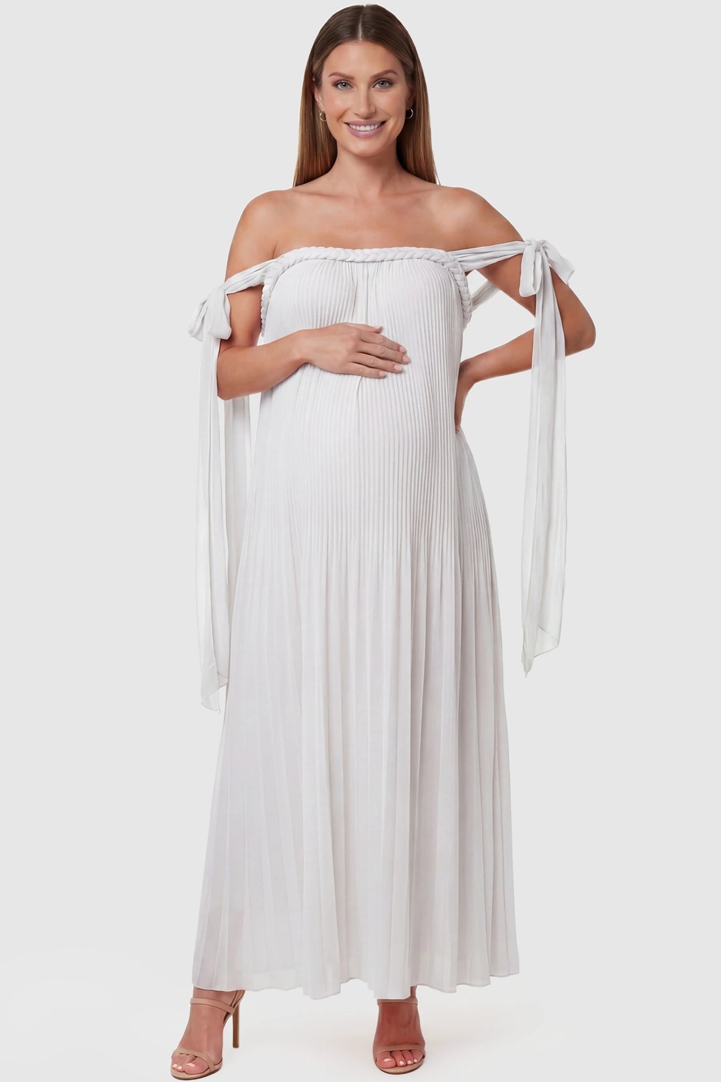 Pleated Braided Cold-Shoulder Maxi Maternity Gown Pleated Braided Cold-Shoulder Maxi Maternity Gown in White featuring tie sleeves and a braided neckline on a pregnant model, front view.