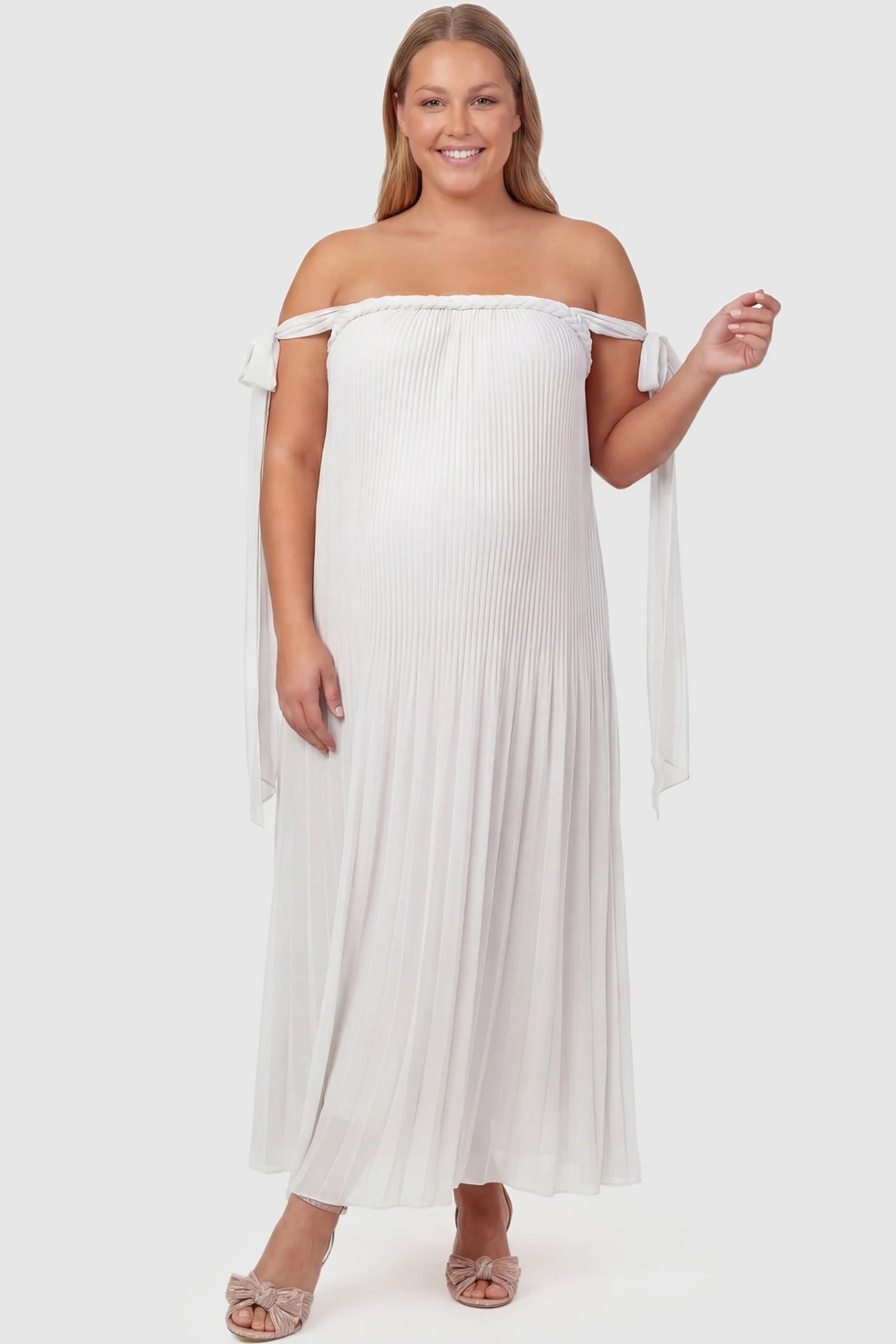 Pleated Braided Cold-Shoulder Maxi Maternity Gown Pleated Braided Cold-Shoulder Maxi Maternity Gown in White featuring a braided neckline on a plus-size pregnant model, front view.