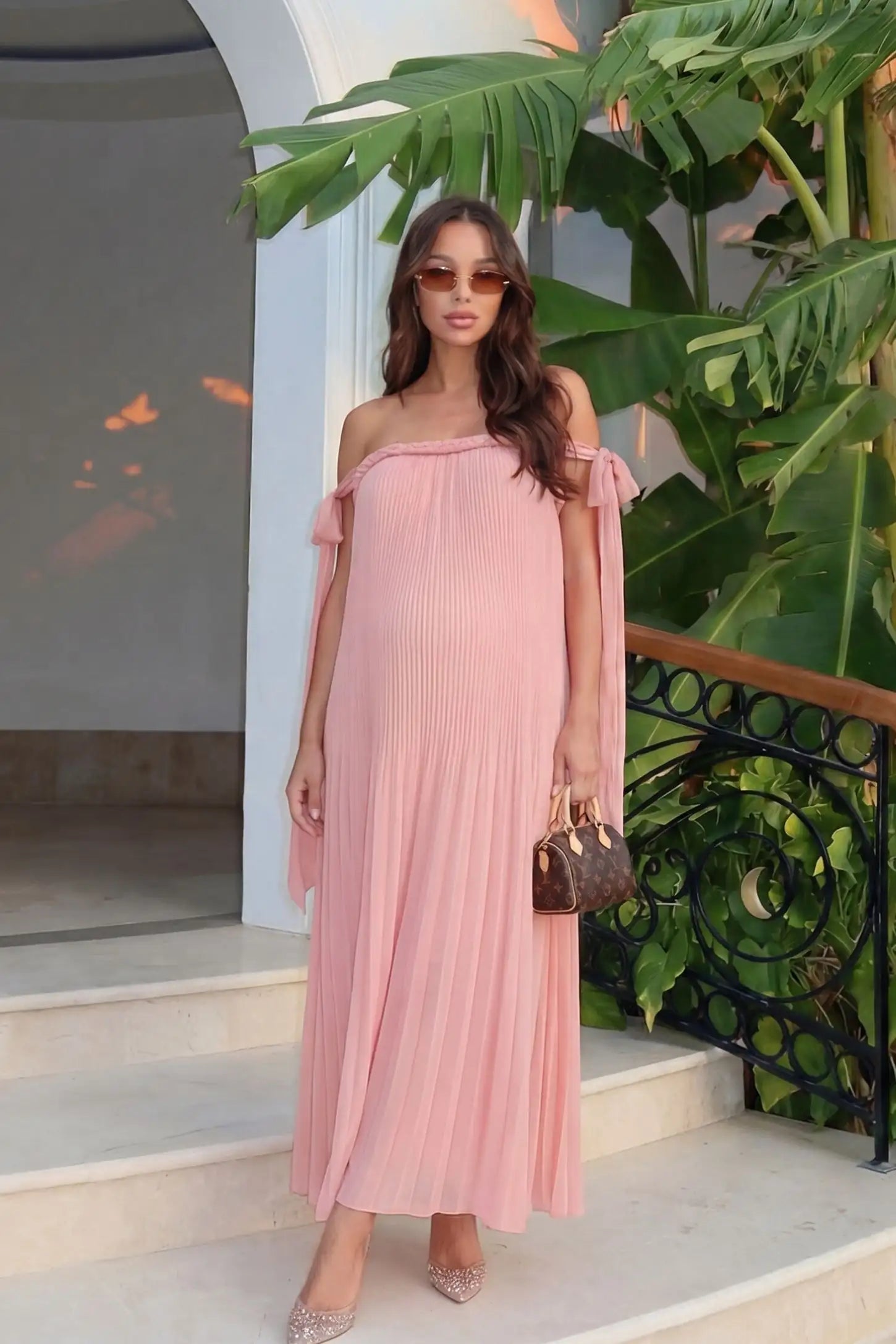 Pleated Braided Cold-Shoulder Maxi Maternity Gown in Pink featuring romantic braided neckline, editorial lifestyle front view on a pregnant model.