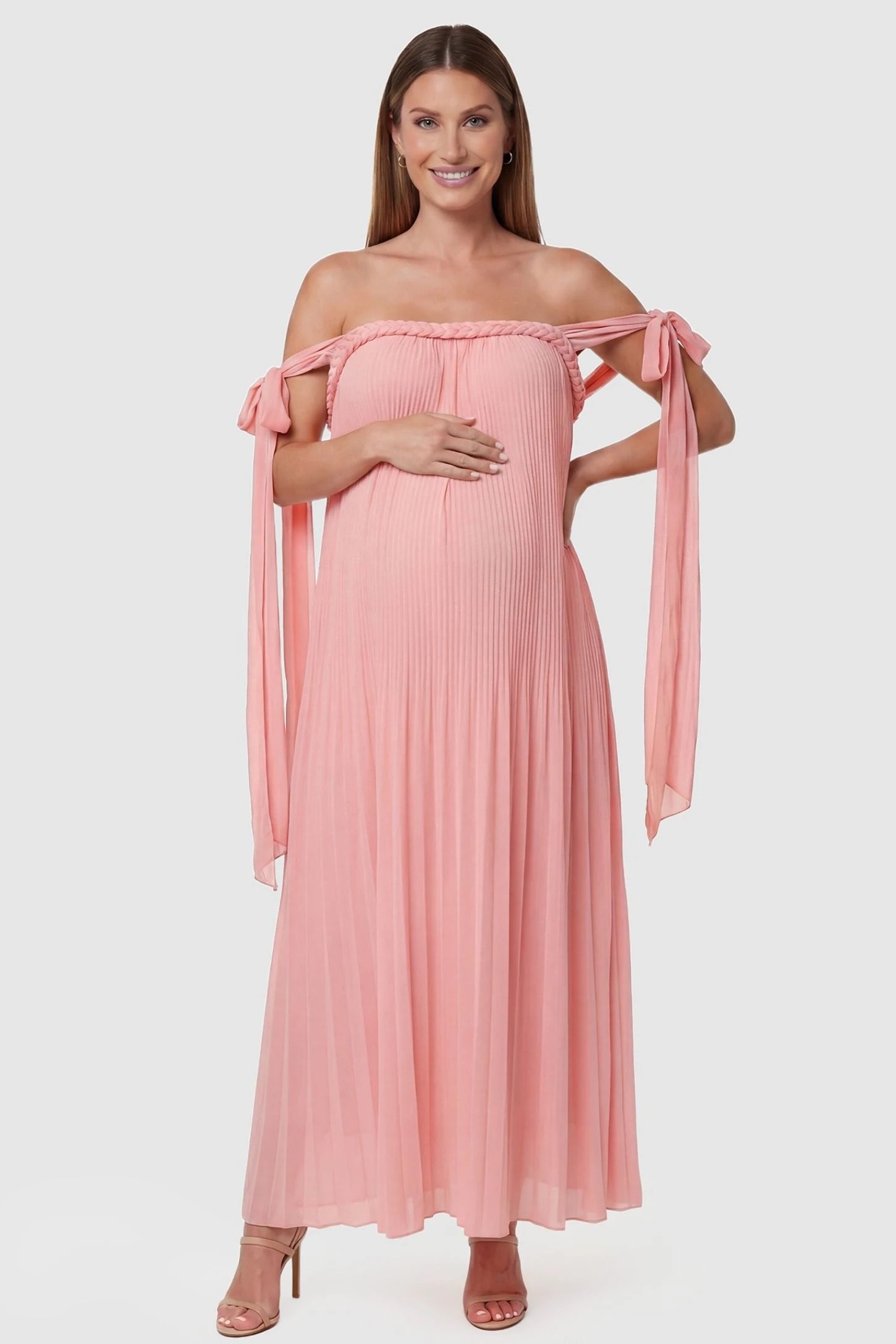 Pleated Braided Cold-Shoulder Maxi Maternity Gown in Pink featuring a braided neckline and pleated floor-length skirt, front view on a pregnant model.