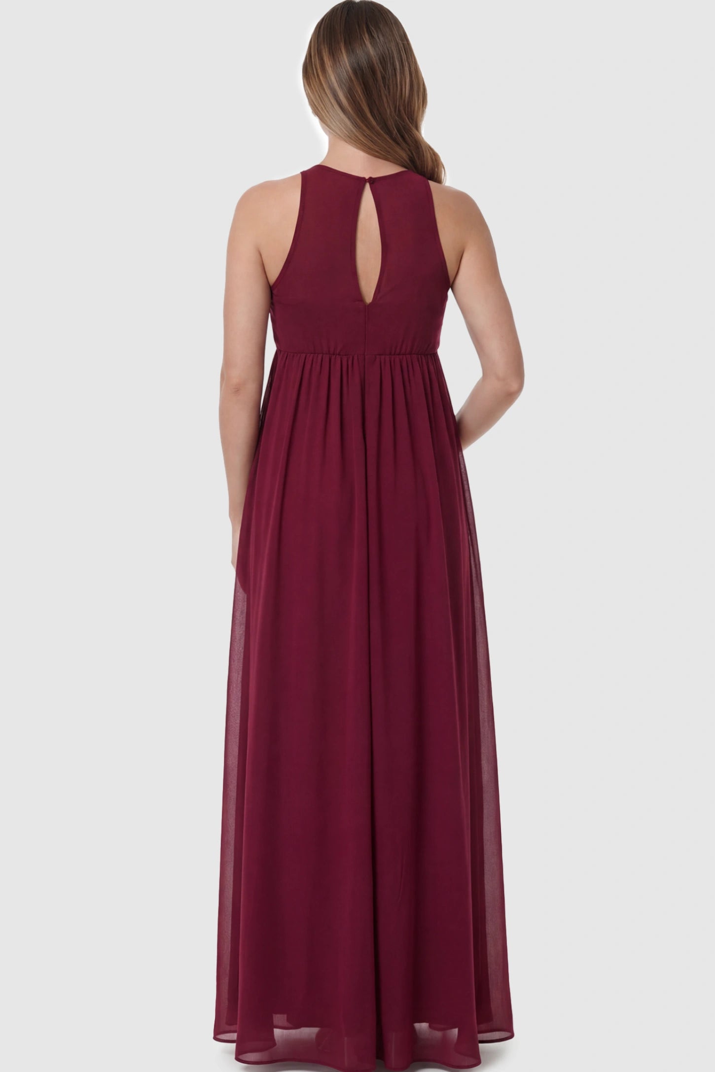 Pleated Mesh Sleeveless Maternity Photoshoot Dress Pleated Mesh Sleeveless Maternity Maxi Dress in burgundy featuring an empire waist on a pregnant model showing back.