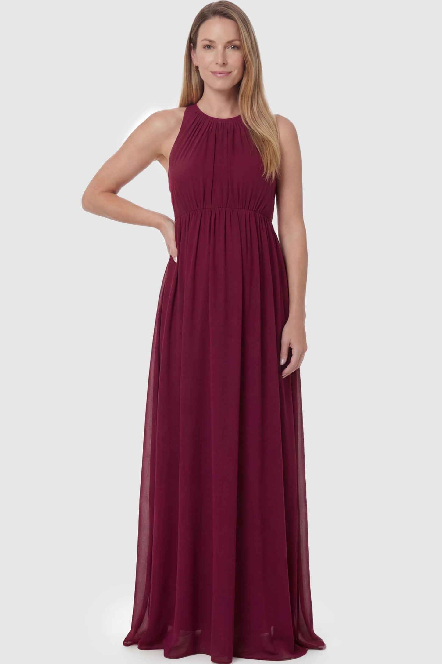 Pleated Mesh Sleeveless Maternity Photoshoot Dress Pleated Mesh Sleeveless Maternity Maxi Dress in burgundy featuring an empire waist on a postpartum model.