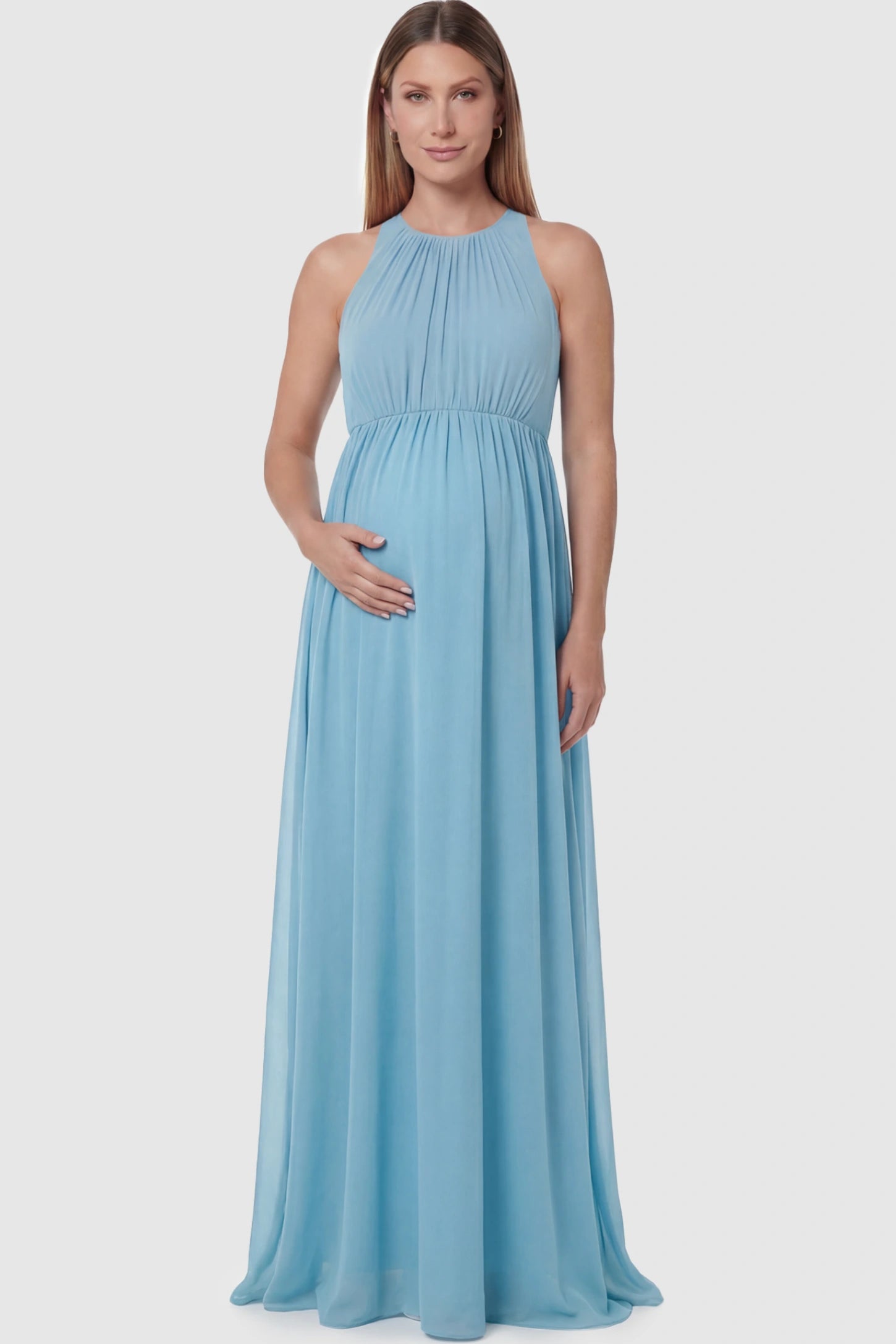 Pleated Mesh Sleeveless Maternity Photoshoot Dress Pleated Mesh Sleeveless Maternity Maxi Dress in light blue featuring an empire waist on a pregnant model posing front.