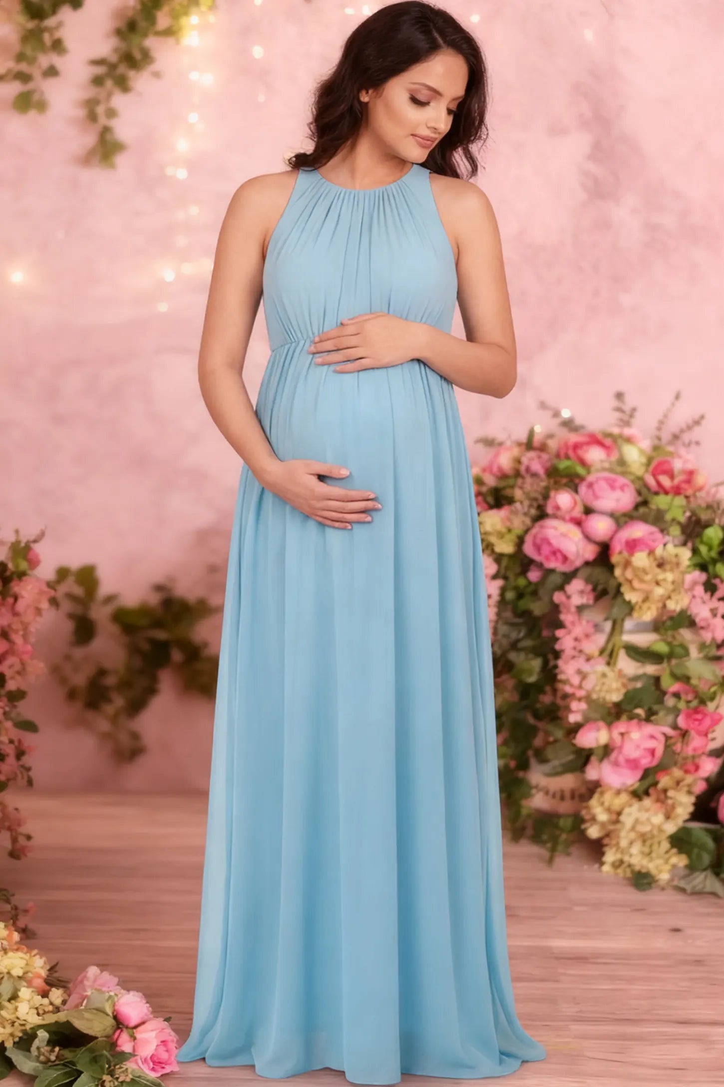 Pleated Mesh Sleeveless Maternity Photoshoot Dress Pleated Mesh Sleeveless Maternity Maxi Dress in light blue featuring an empire waist on a pregnant woman.