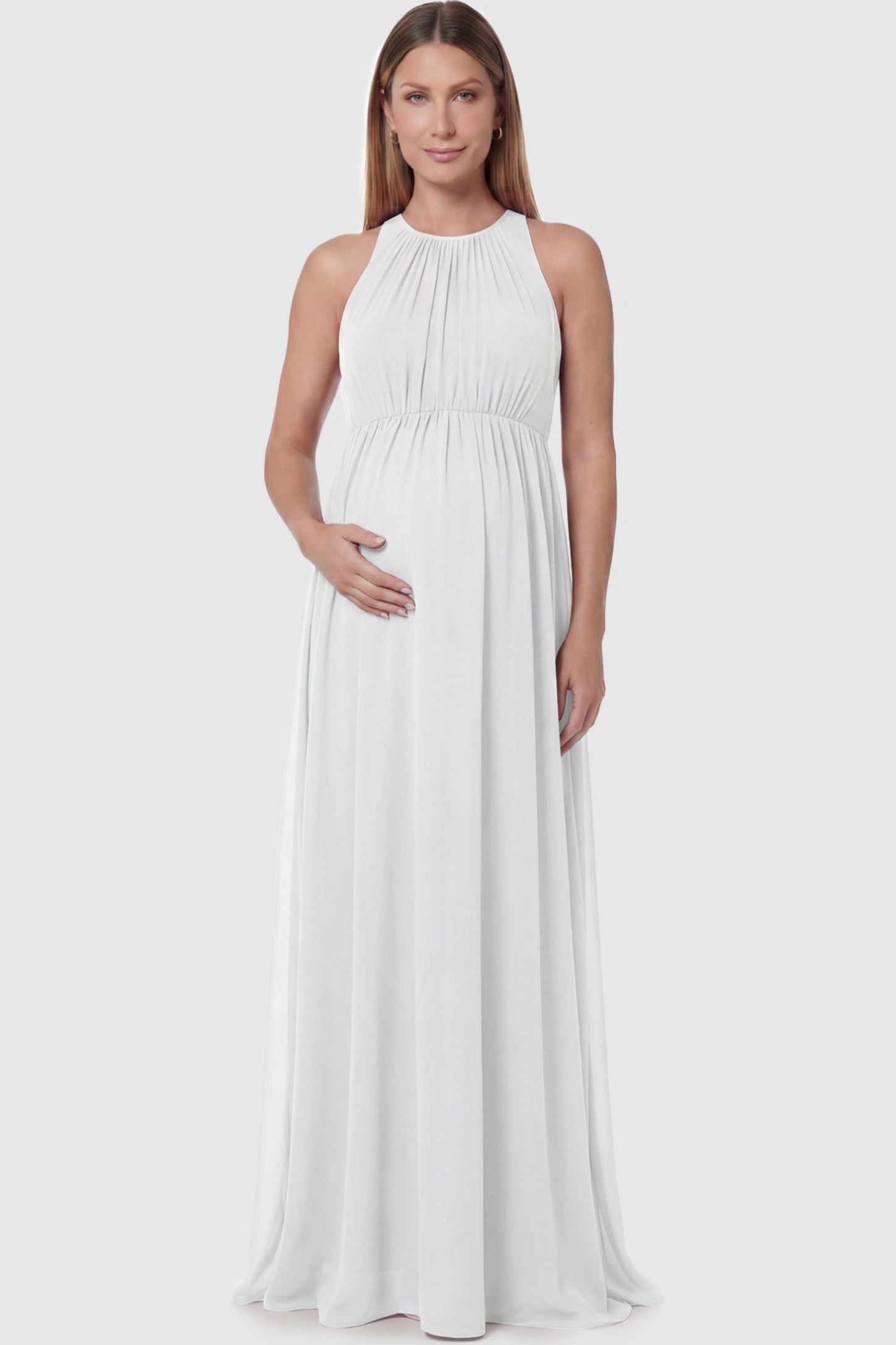 Pleated Mesh Sleeveless Maternity Photoshoot Dress Pleated Mesh Sleeveless Maternity Maxi Dress in white featuring an empire waist on a pregnant model posing front.
