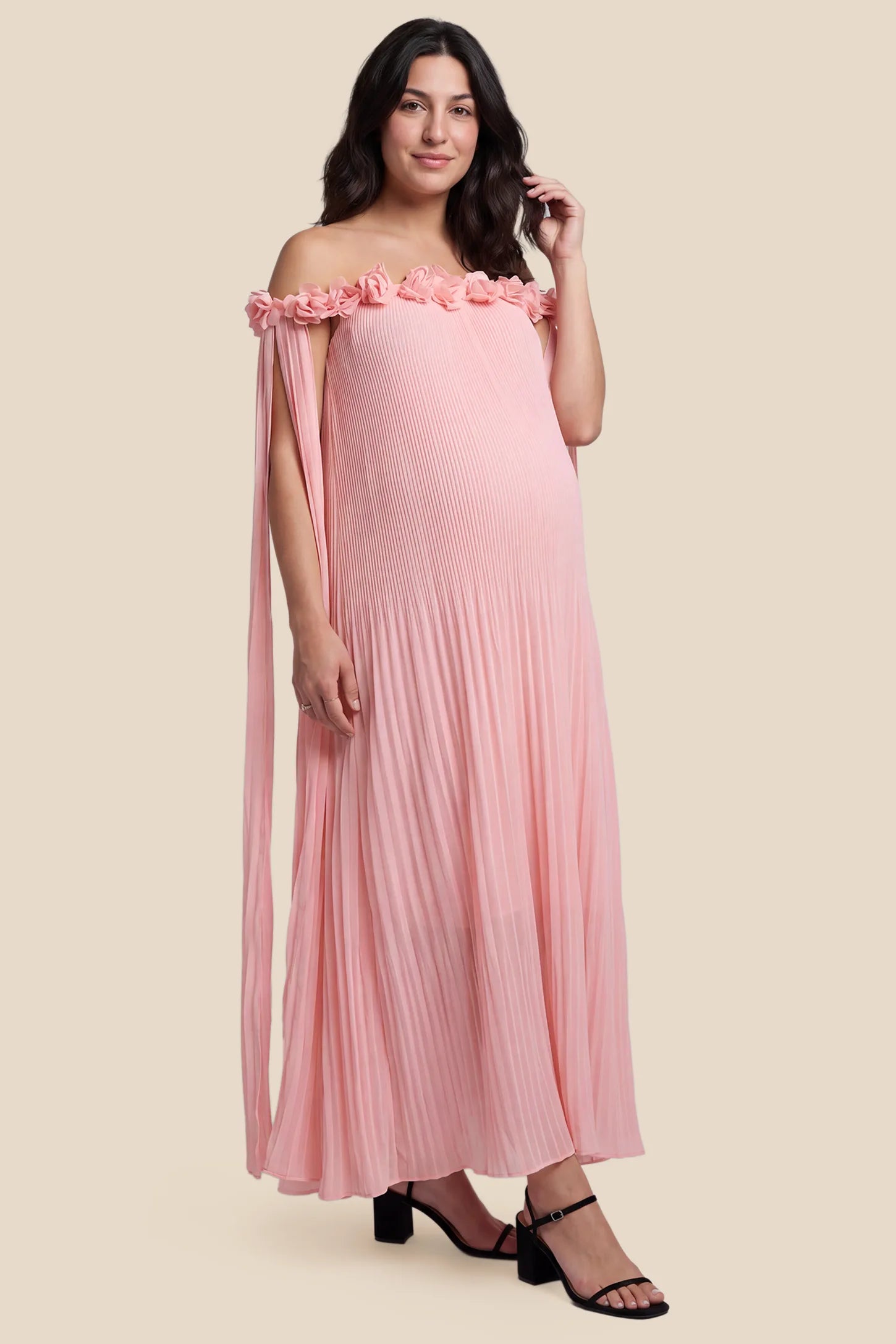 Pleated Off-Shoulder Maternity Gown with Rosettes Pleated Off-Shoulder Maternity Gown with Rosettes in Pink featuring an off-shoulder neckline and rosette accents, front view on a pregnant model.