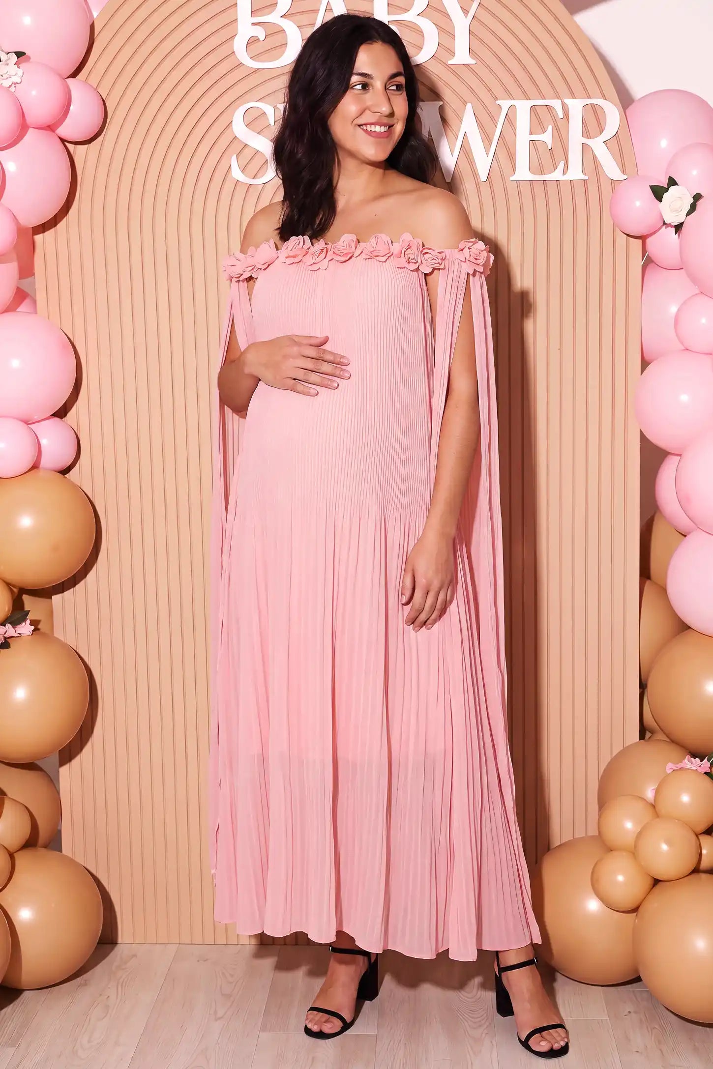 Pleated Off-Shoulder Maternity Gown with Rosettes Pleated Off-Shoulder Maternity Gown with Rosettes in Pink with romantic rosette details, lifestyle view on a plus-size model.