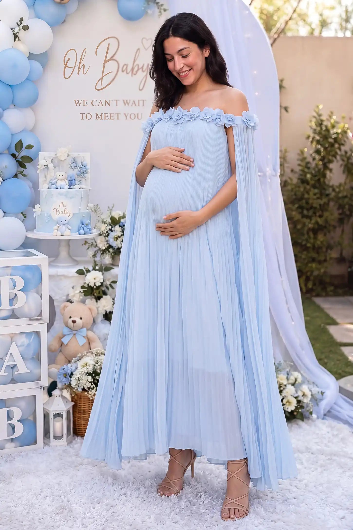 Pleated Off-Shoulder Maternity Gown with Rosettes Pleated Off-Shoulder Maternity Gown with Rosettes in Skye Blue with pleated details, lifestyle view on a pregnant model.