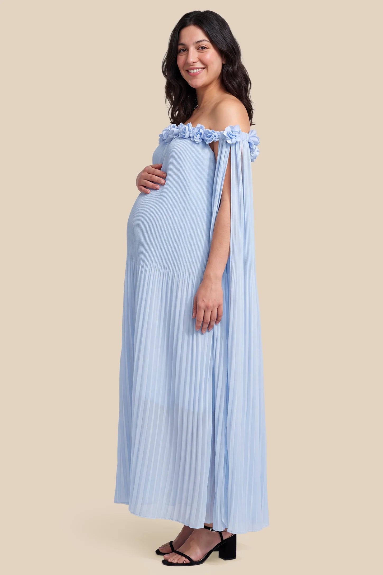 Pleated Off-Shoulder Maternity Gown with Rosettes Pleated Off-Shoulder Maternity Gown with Rosettes in Skye Blue with fluid pleats, side view on a pregnant model.