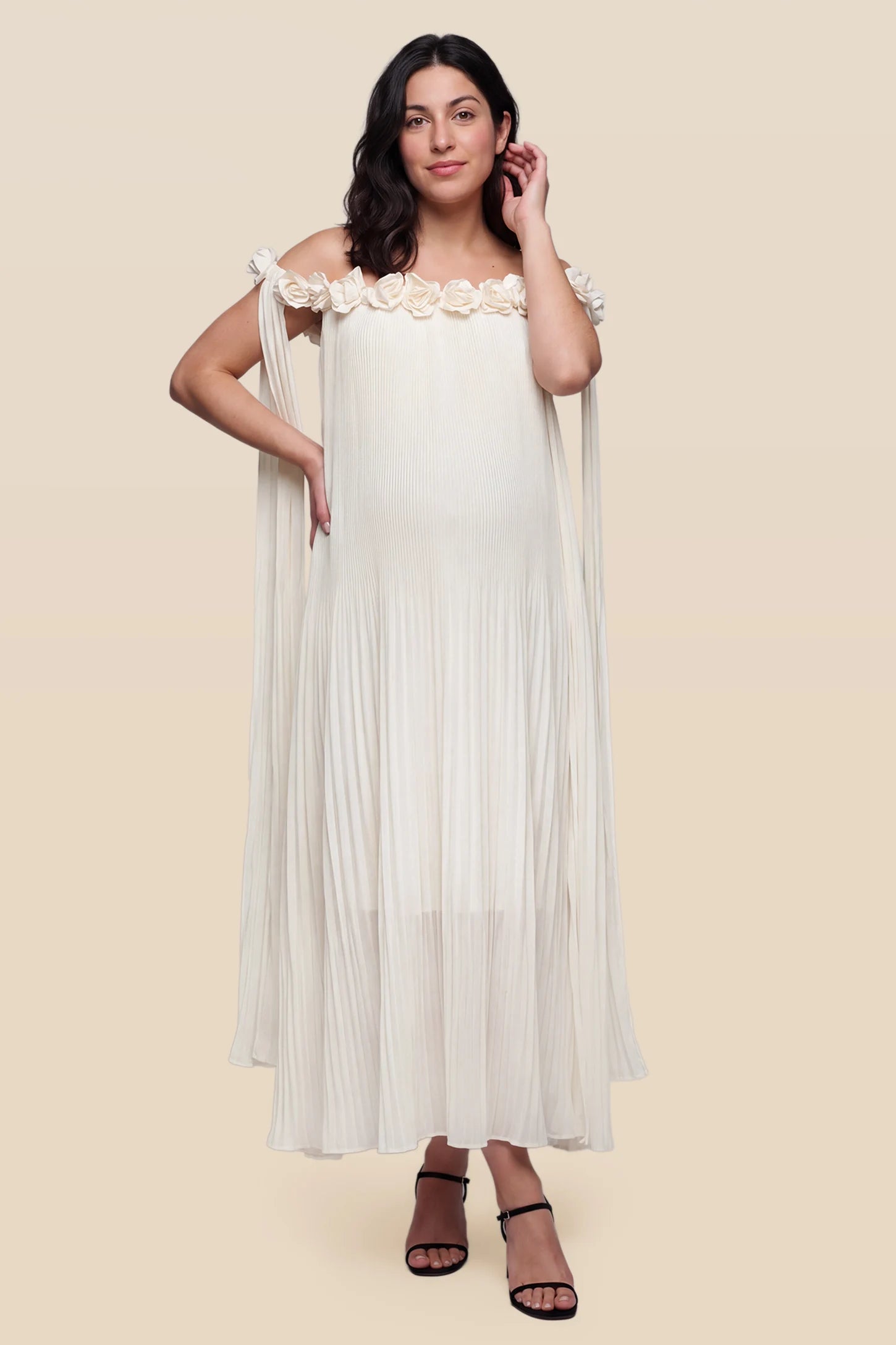 Pleated Off-Shoulder Maternity Gown with Rosettes Pleated Off-Shoulder Maternity Gown with Rosettes in White featuring an off-shoulder neckline and delicate rosette accents, front view on a pregnant model.