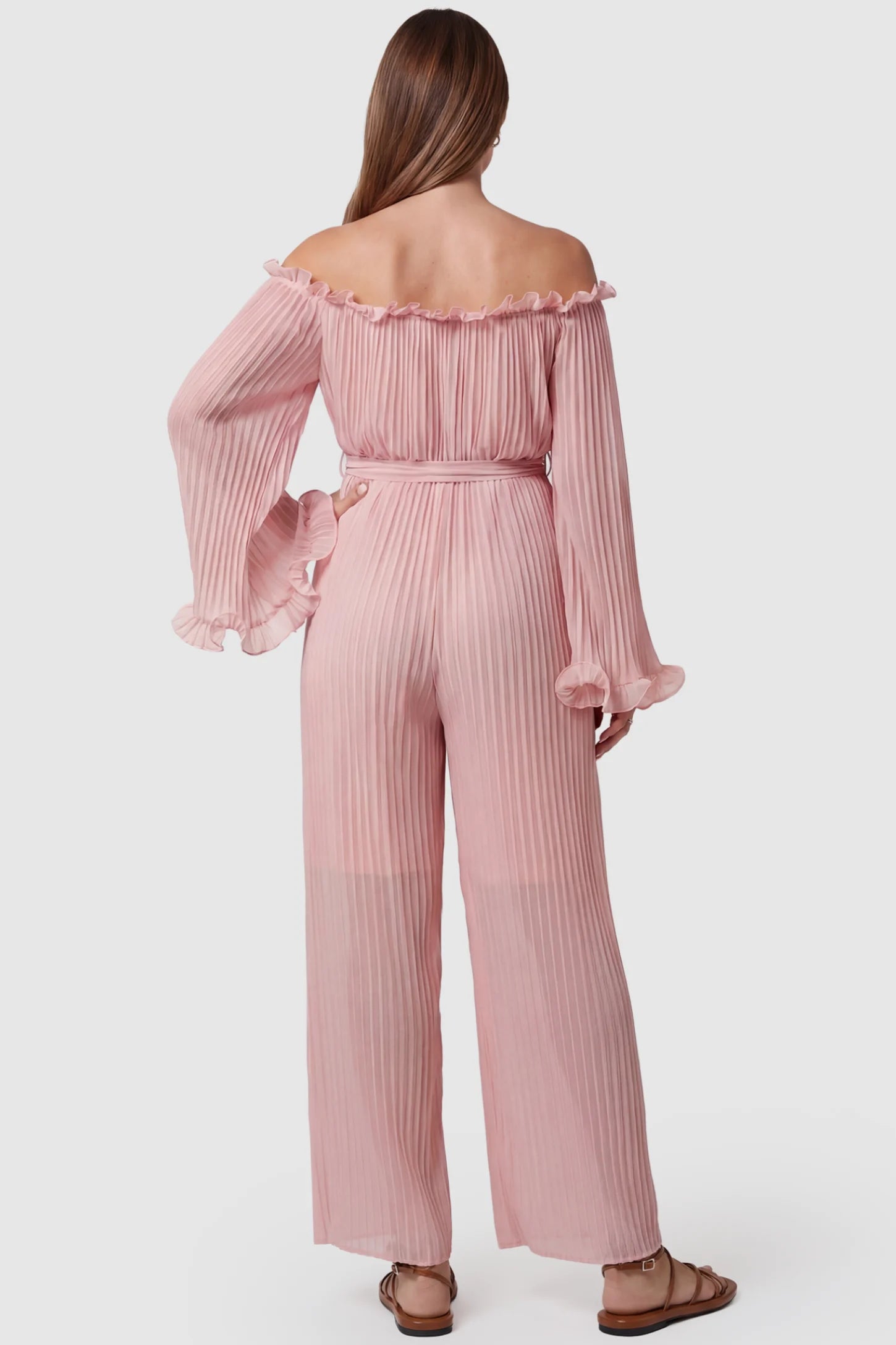 Pleated Off Shoulder Tie-Waist Maternity Jumpsuit Pleated Off Shoulder Tie-Waist Maternity Jumpsuit in Pink featuring a wide-leg silhouette on a pregnant model, back view.