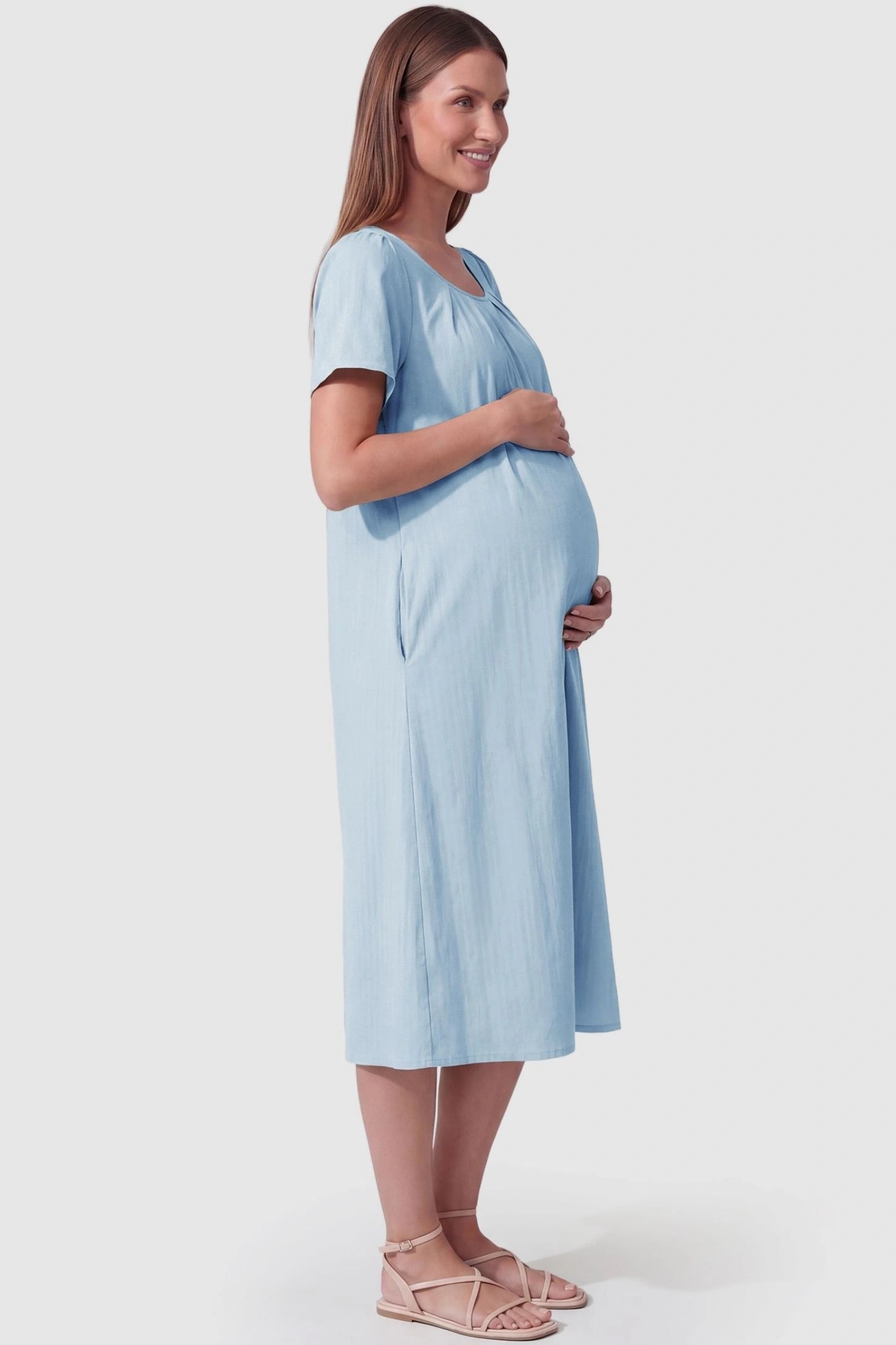 Pleated Round Neck Flowy Midi Maternity Dress  Pleated Round Neck Flowy Midi Maternity Dress in Blue featuring a flowy silhouette on a pregnant model, side view.