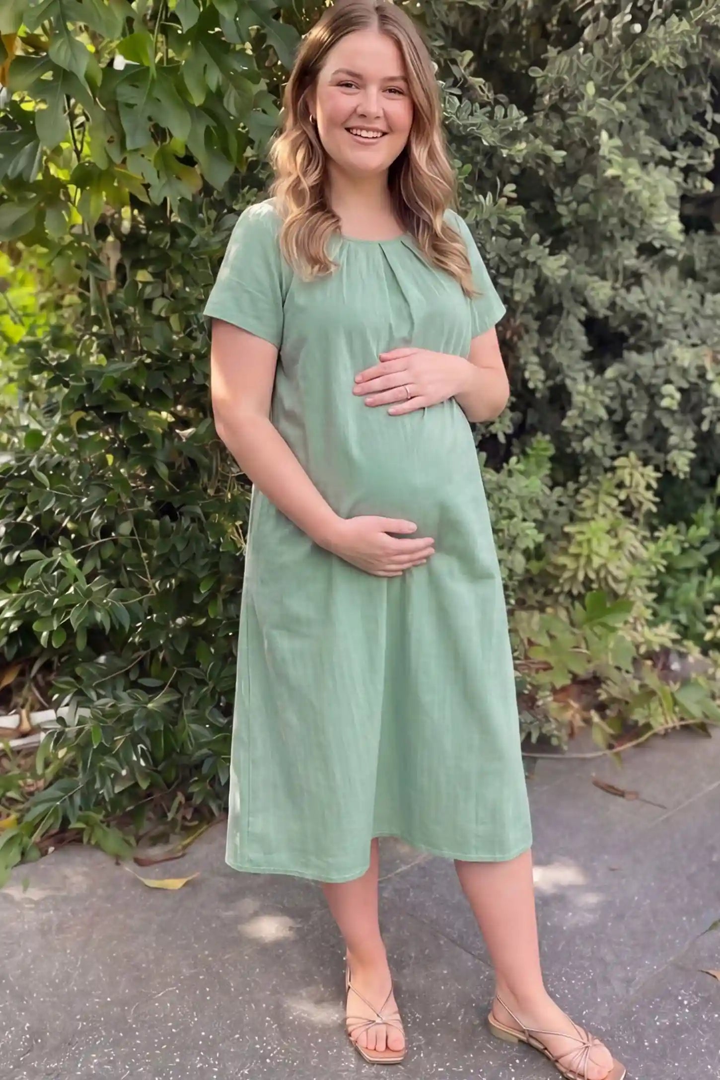 Pleated Round Neck Flowy Midi Maternity Dress Pleated Round Neck Flowy Midi Maternity Dress in Lake Blue featuring a pleated neckline on a pregnant model, front view.
