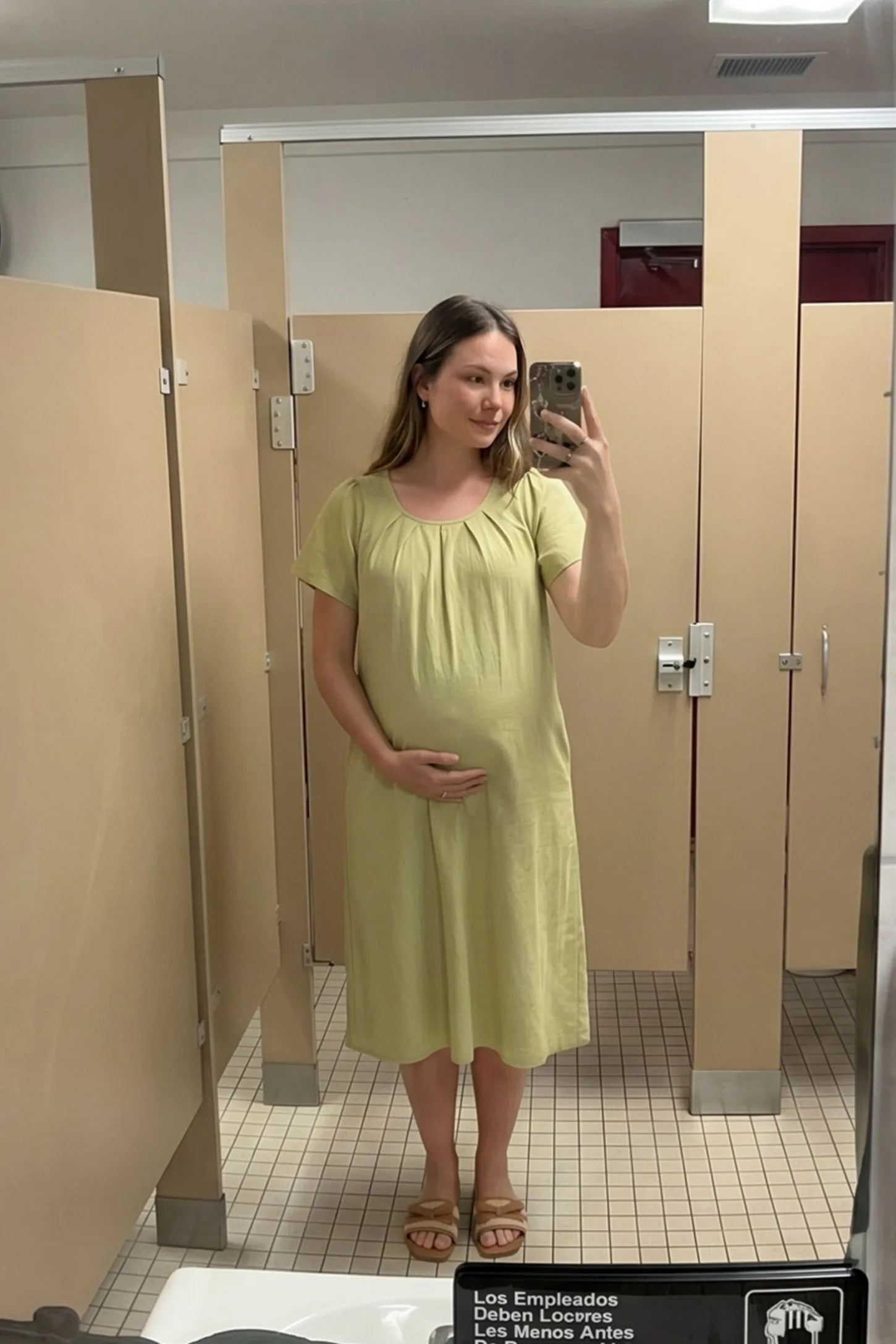 Pleated Round Neck Flowy Midi Maternity Dress Pleated Round Neck Flowy Midi Maternity Dress in Light Green featuring comfortable short sleeves on a pregnant model, mirror selfie.