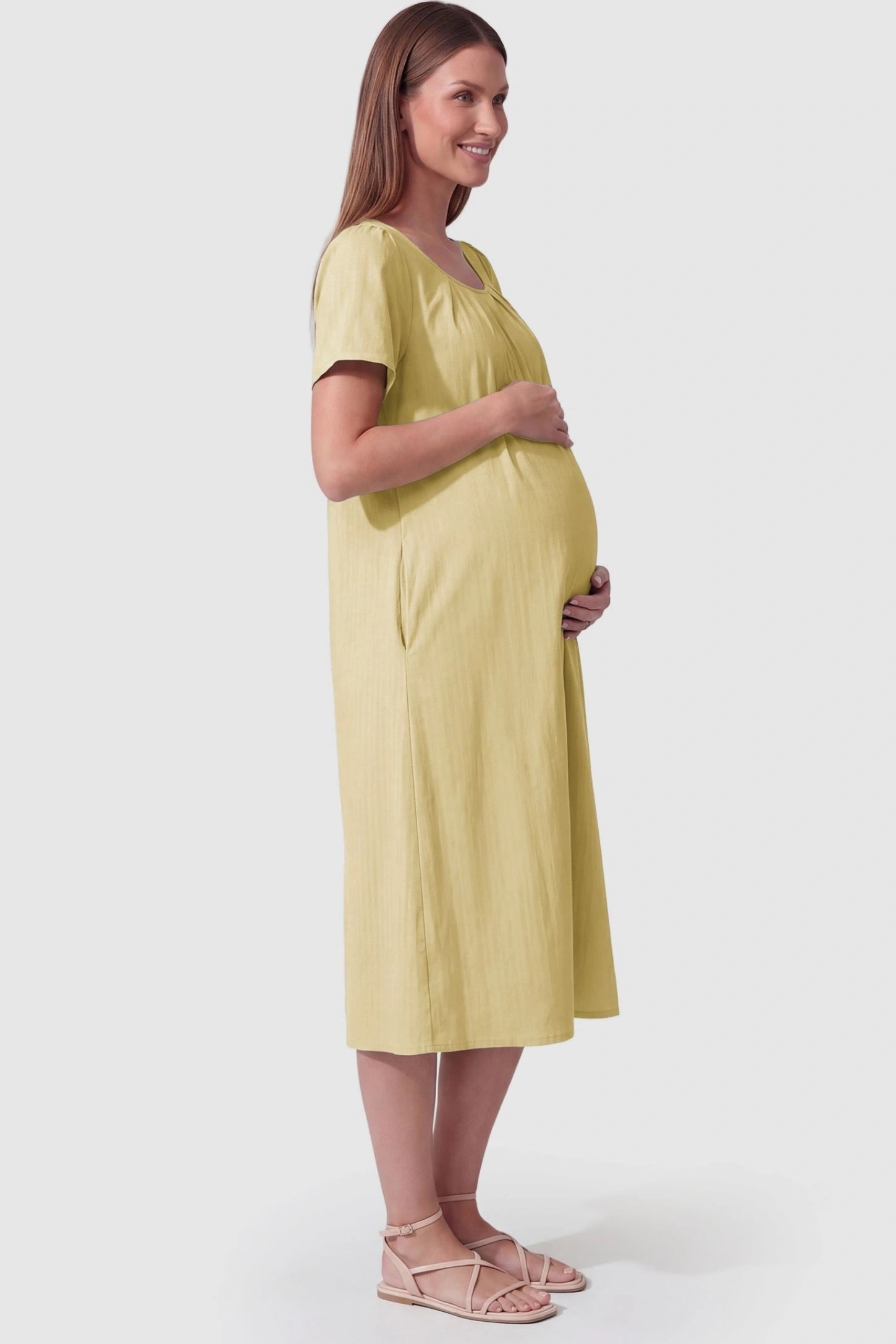 Pleated Round Neck Flowy Midi Maternity Dress Pleated Round Neck Flowy Midi Maternity Dress in Yellow featuring a flowy silhouette on a pregnant model, side view.