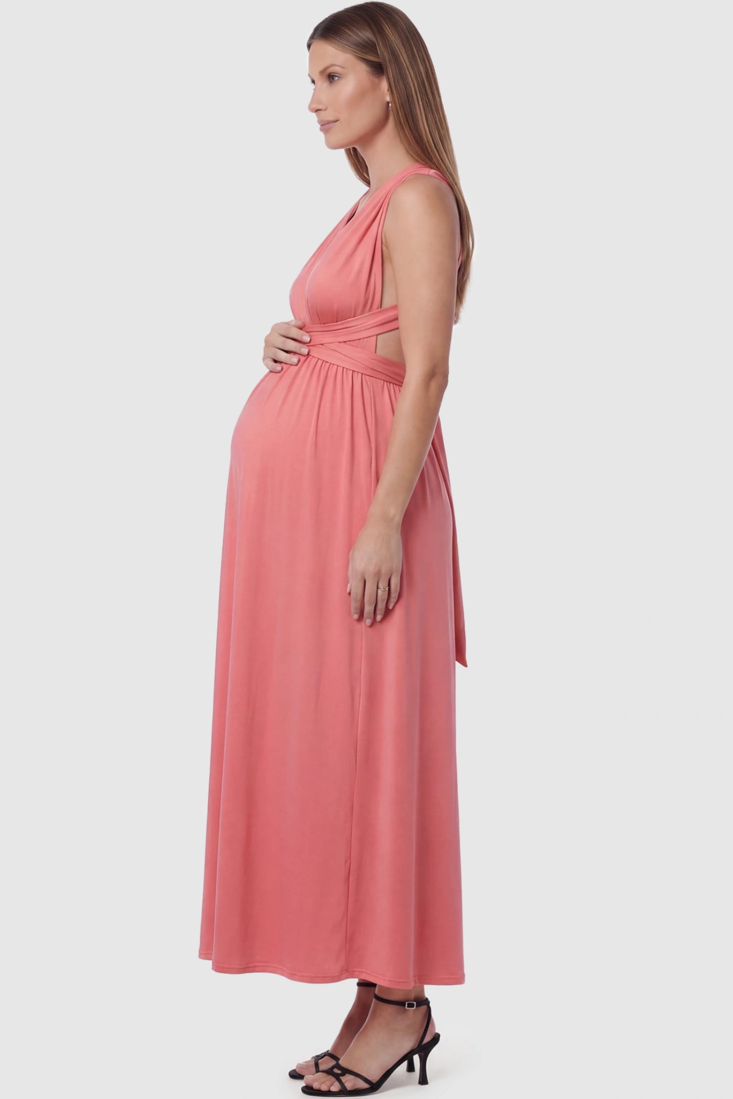 Plunging Halter Empire Waist Maternity Maxi Dress Plunging Halter Empire Waist Maternity Maxi Dress in Pink featuring high-stretch fabric on a pregnant model in a studio setting showing side.