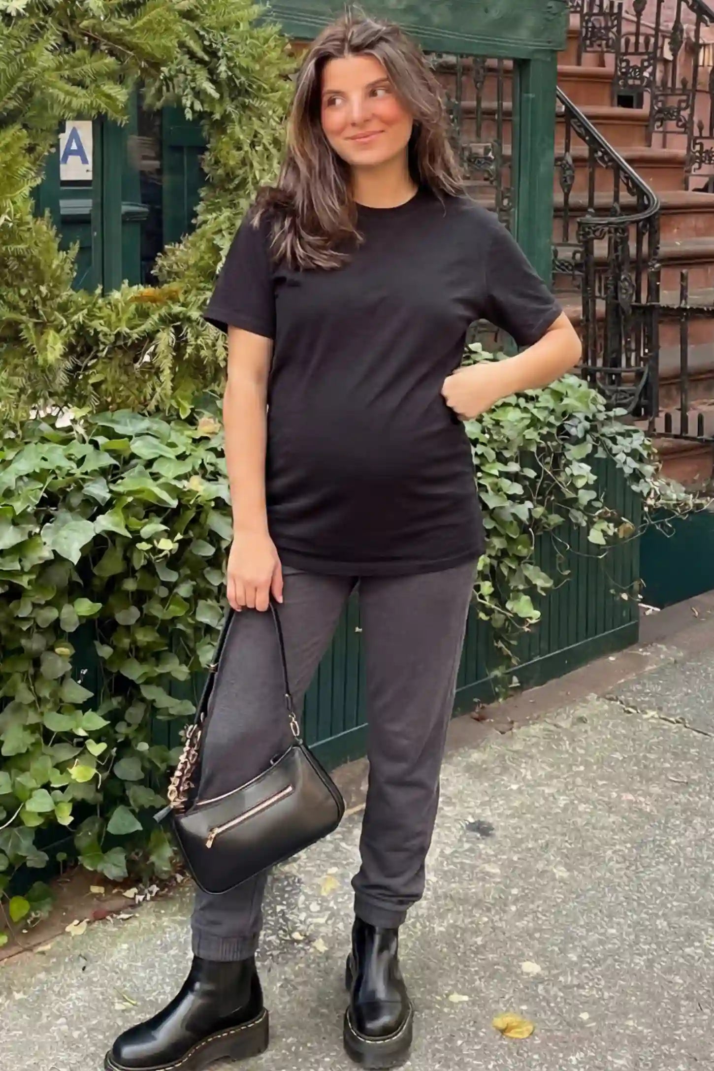 Full Panel Pocketed Maternity Jogger Pants Full Panel Pocketed Maternity Jogger Pants in Black featuring a jersey belly panel on a pregnant woman in outdoor setting, front view.
