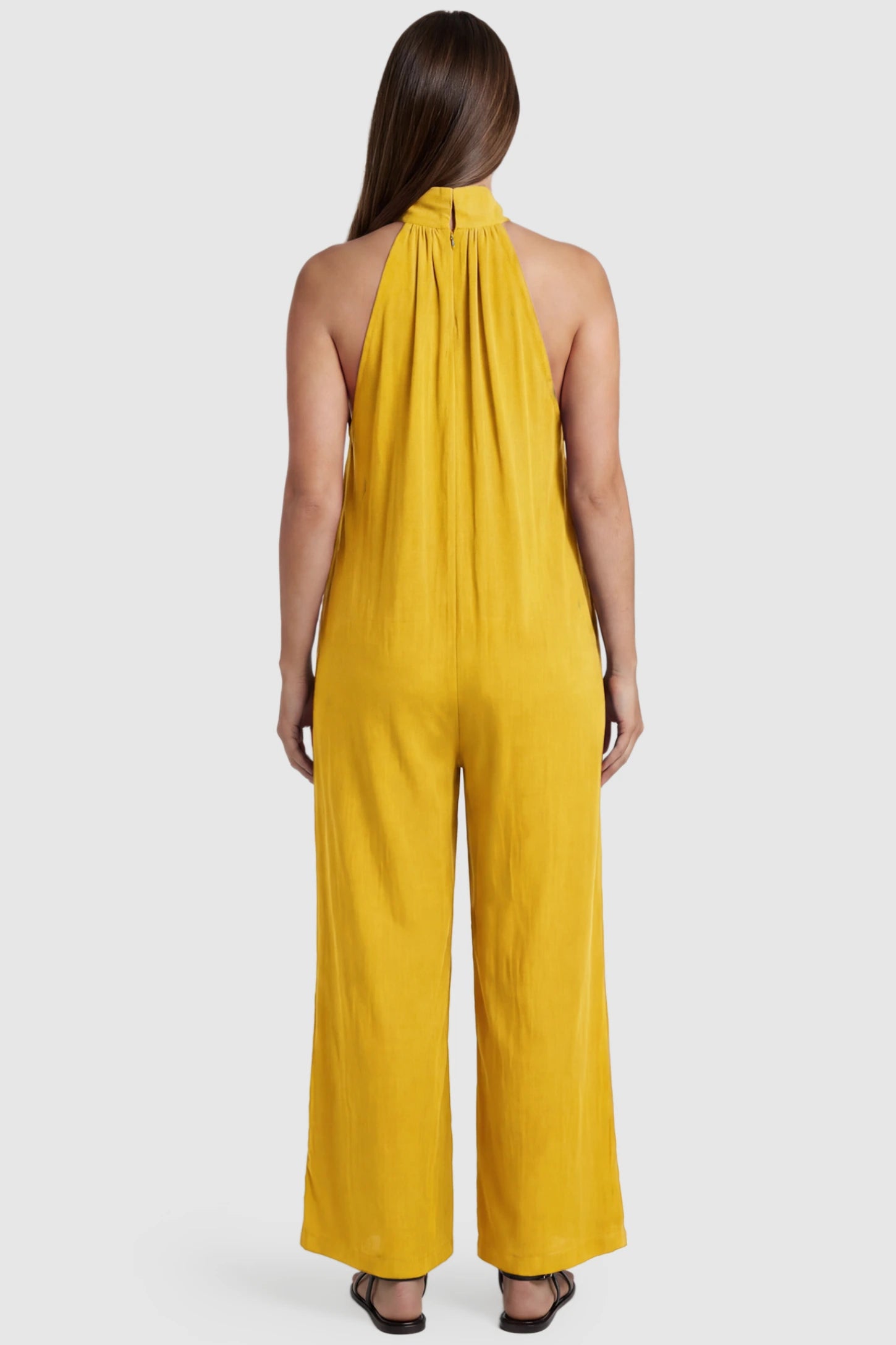 Pocketed Mock Neck Sleeveless Maternity Jumpsuit Pocketed Mock Neck Sleeveless Maternity Jumpsuit in yellow featuring a high gathered neckline, side pockets shown on a pregnant model, back view.