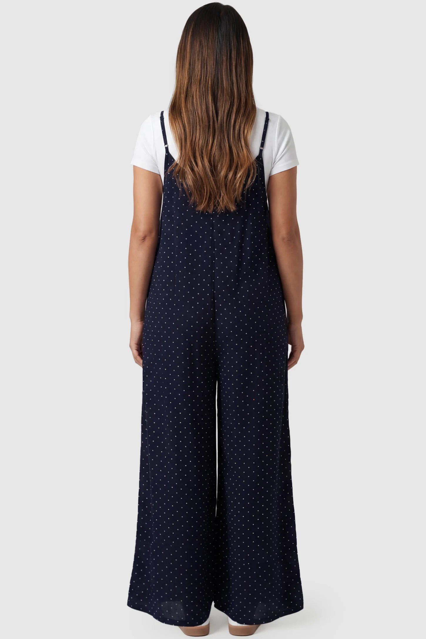 Pocketed Spaghetti Strap Wide Leg Maternity Jumpsuit Pocketed Spaghetti Strap Wide Leg Maternity Jumpsuit in Blue featuring loose fitting silhouette and pockets on a pregnant model, back view.