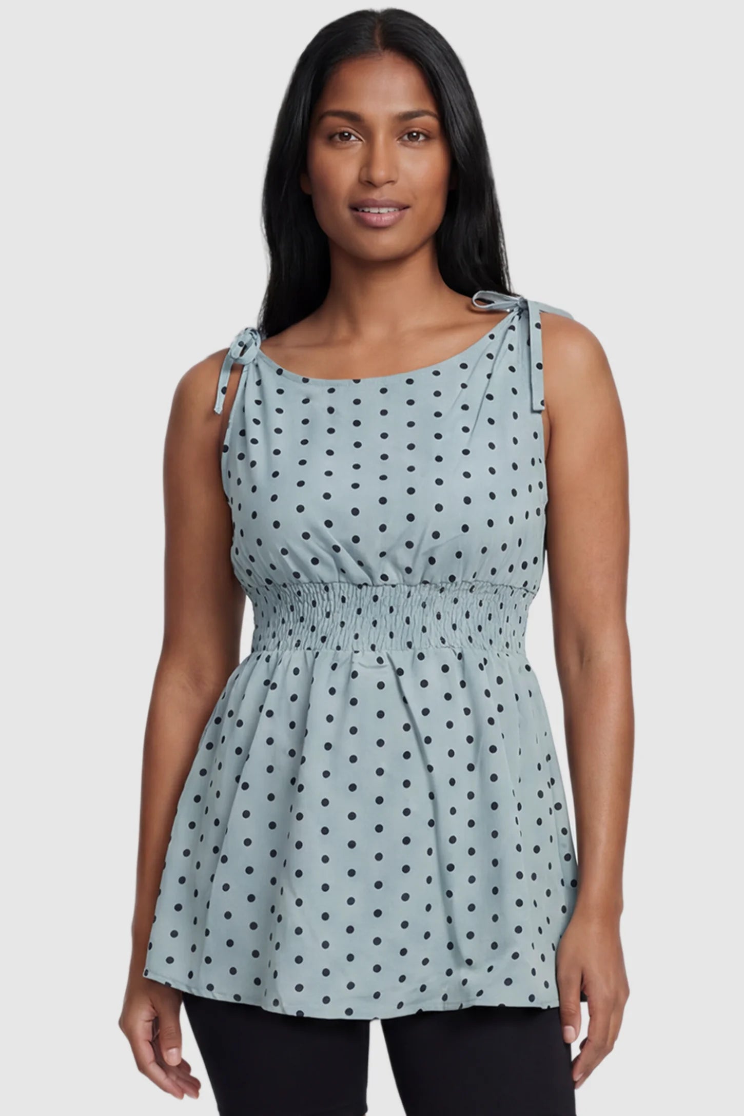 Polka Dot Round Neck Flowy Maternity Top Polka Dot Flowy Maternity Top in Blue featuring a smocked elastic waistband and shoulder ties on a postpartum model, front view.
