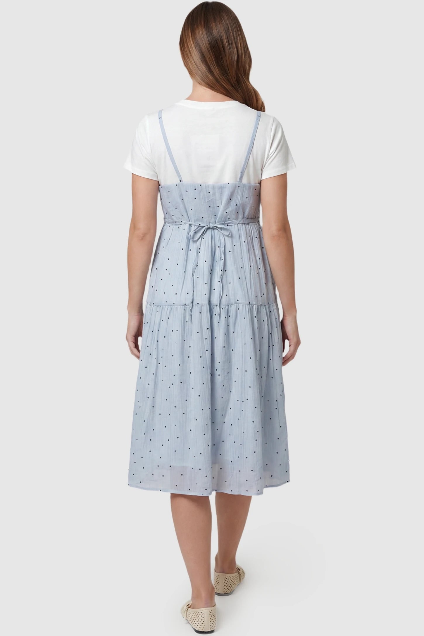 Polka Dot Round Neck Tiered Midi Maternity Dress Polka Dot Round Neck Tiered Midi Maternity Dress in Blue featuring an adjustable back tie and thin shoulder straps on a pregnant model, back view.