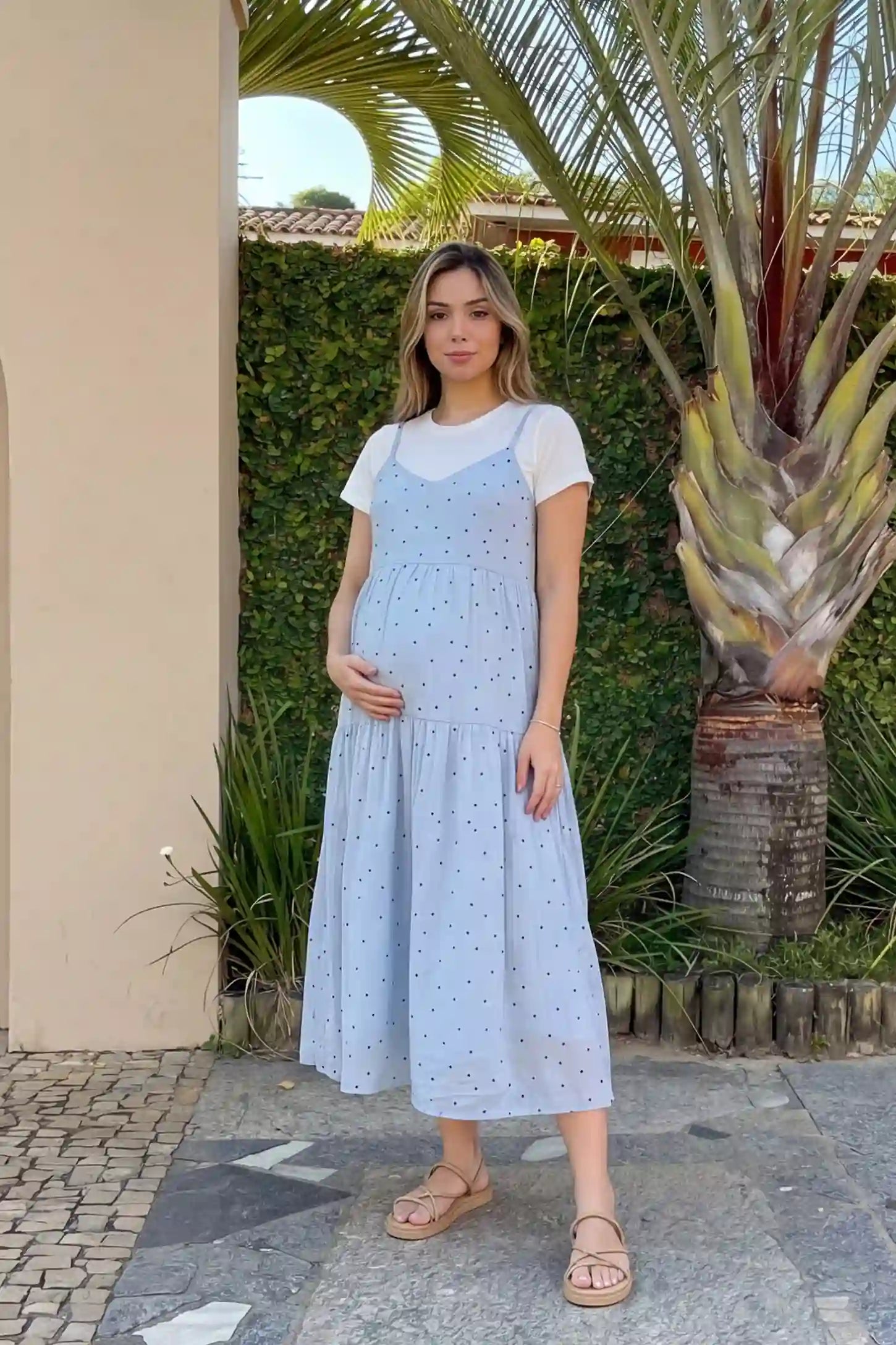 Polka Dot Round Neck Tiered Midi Maternity Dress in Blue featuring a breezy tiered midi length and thin shoulder straps on a pregnant model, front view.