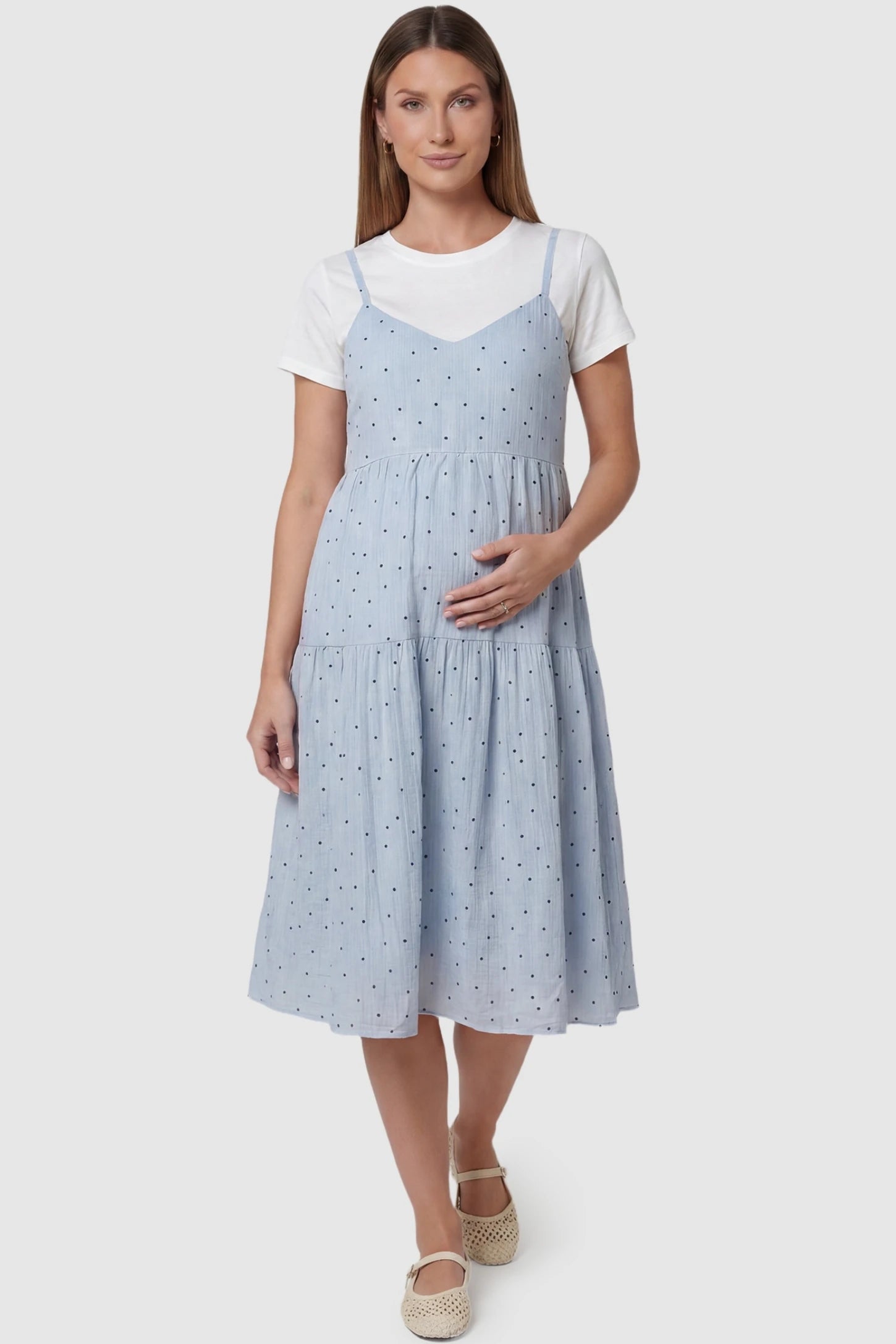 Polka Dot Round Neck Tiered Midi Maternity Dress in Blue featuring a round neckline and adjustable back tie on a pregnant model, front view.