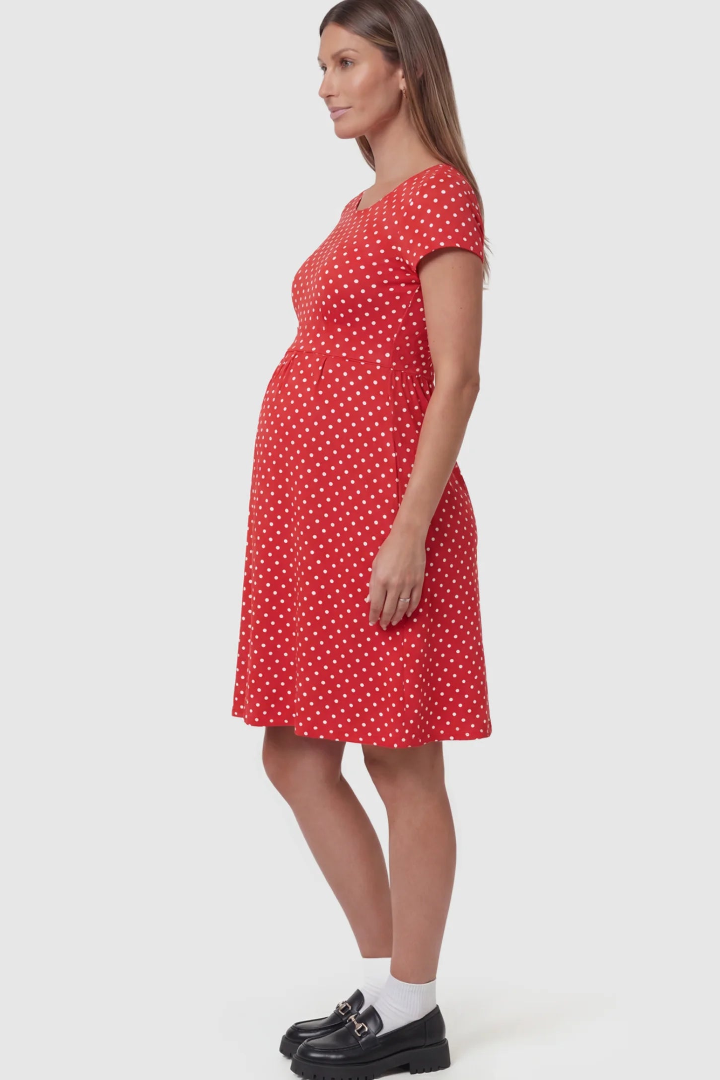 Polka Dot Scoop Neck Maternity Nursing Dress Polka Dot Scoop Neck Midi Maternity Nursing Dress in red featuring a discreet lift-up layer on a pregnant model showing side.