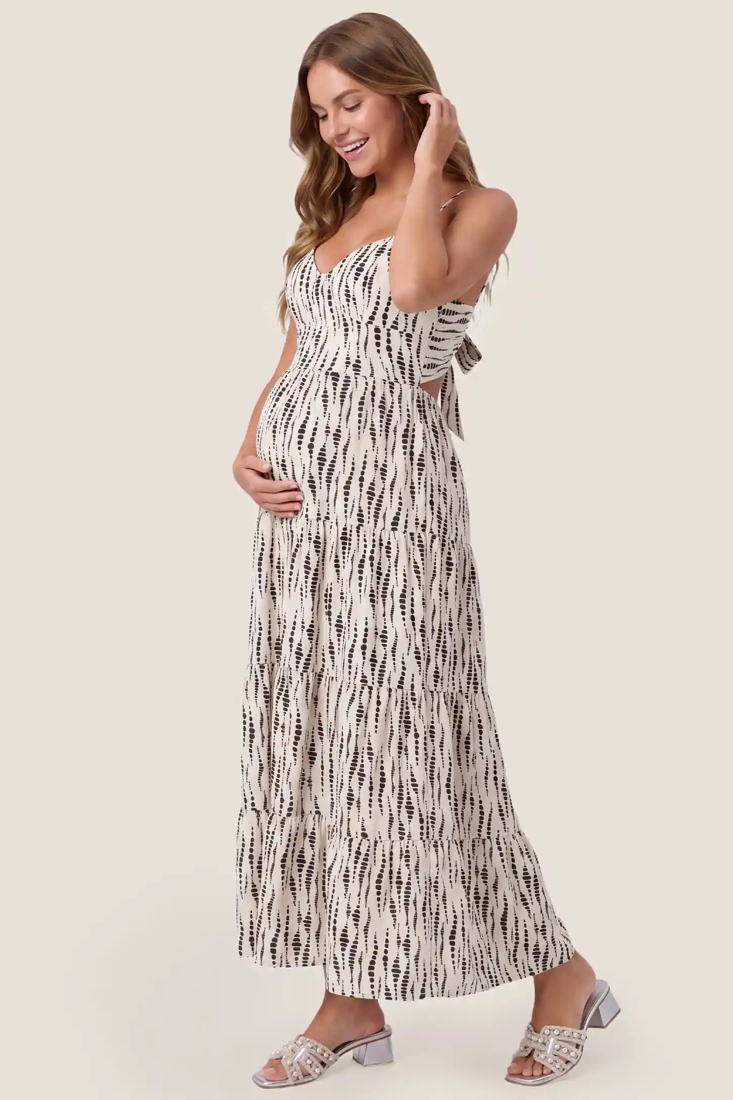 Print Tiered Cami Maternity Maxi Dress Print Tiered Cami Maternity Maxi Dress in Ivory Dash Print with an accommodating tiered silhouette, side view on a pregnant model.