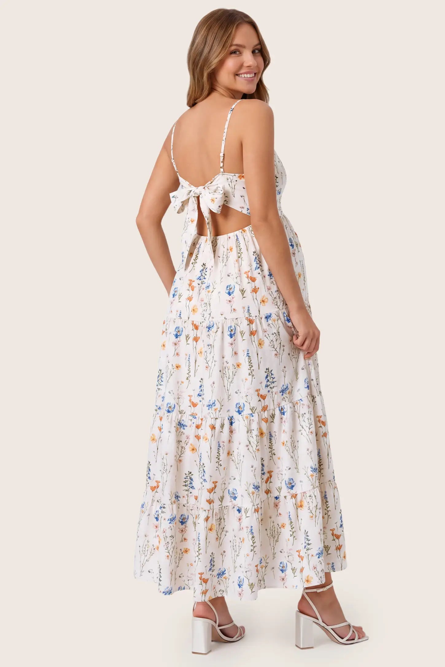Print Tiered Cami Maternity Maxi Dress Print Tiered Cami Maternity Maxi Dress in White showcasing the cutout back with tie-up detail, back view on a pregnant model.