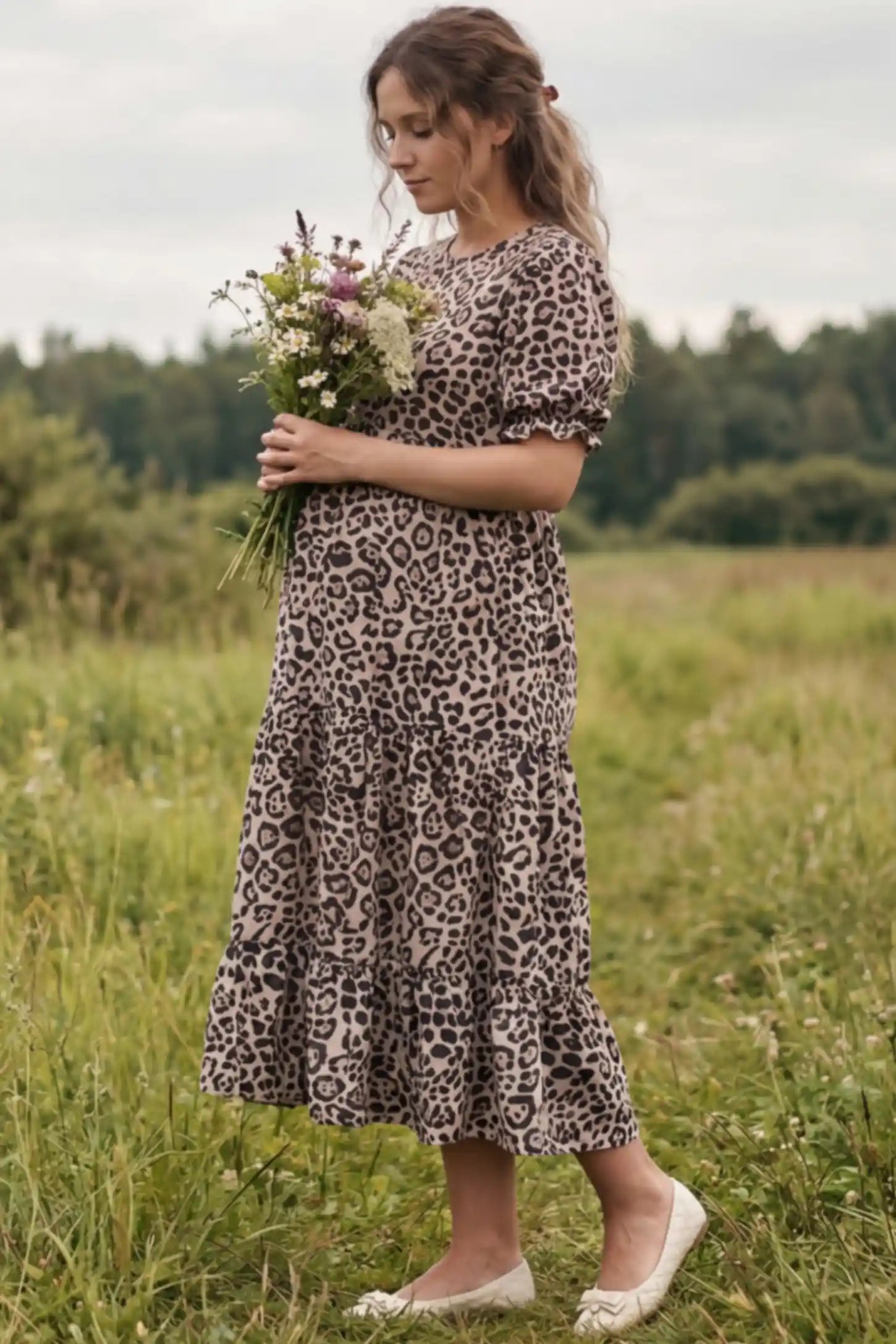 Printed Short Sleeve Tiered Maternity Midi Dress Printed Short Sleeve Tiered Maternity Midi Dress in leopard print featuring round neck, tiered A-line skirt on a pregnant woman in outdoor setting, side view.