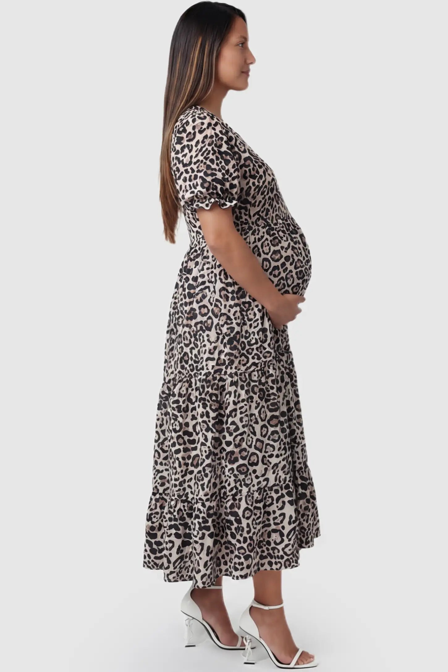 Printed Short Sleeve Tiered Maternity Midi Dress Printed Short Sleeve Tiered Maternity Midi Dress in leopard print featuring round neck, tiered A-line skirt on a pregnant model, side view.