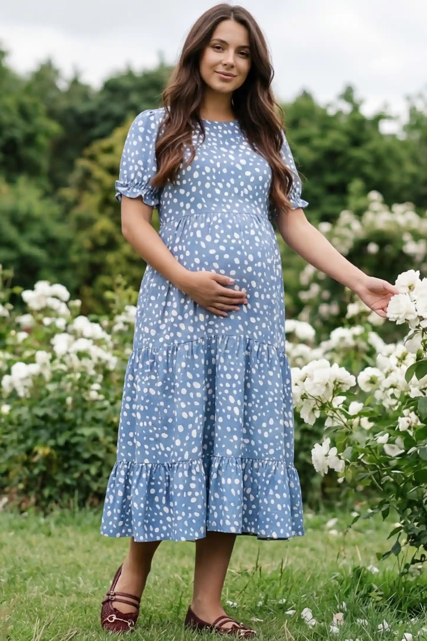 Printed Short Sleeve Tiered Maternity Midi Dress Printed Short Sleeve Tiered Maternity Midi Dress in light blue featuring round neck, tiered A-line skirt on a pregnant woman in outdoor setting, front view.