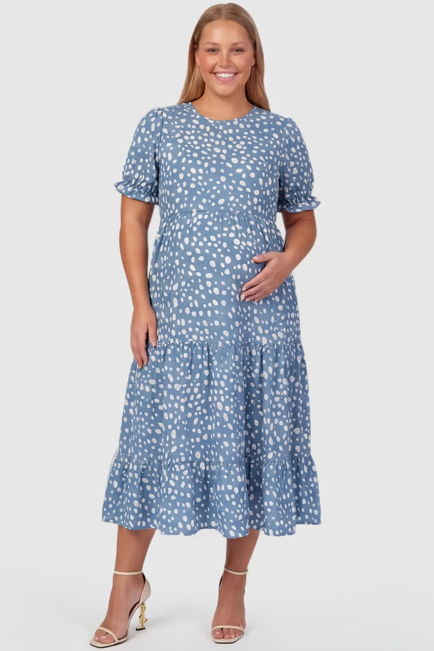 Printed Short Sleeve Tiered Maternity Midi Dress Printed Short Sleeve Tiered Maternity Midi Dress in light blue featuring round neck, tiered A-line skirt on a plus size pregnant model, front view.