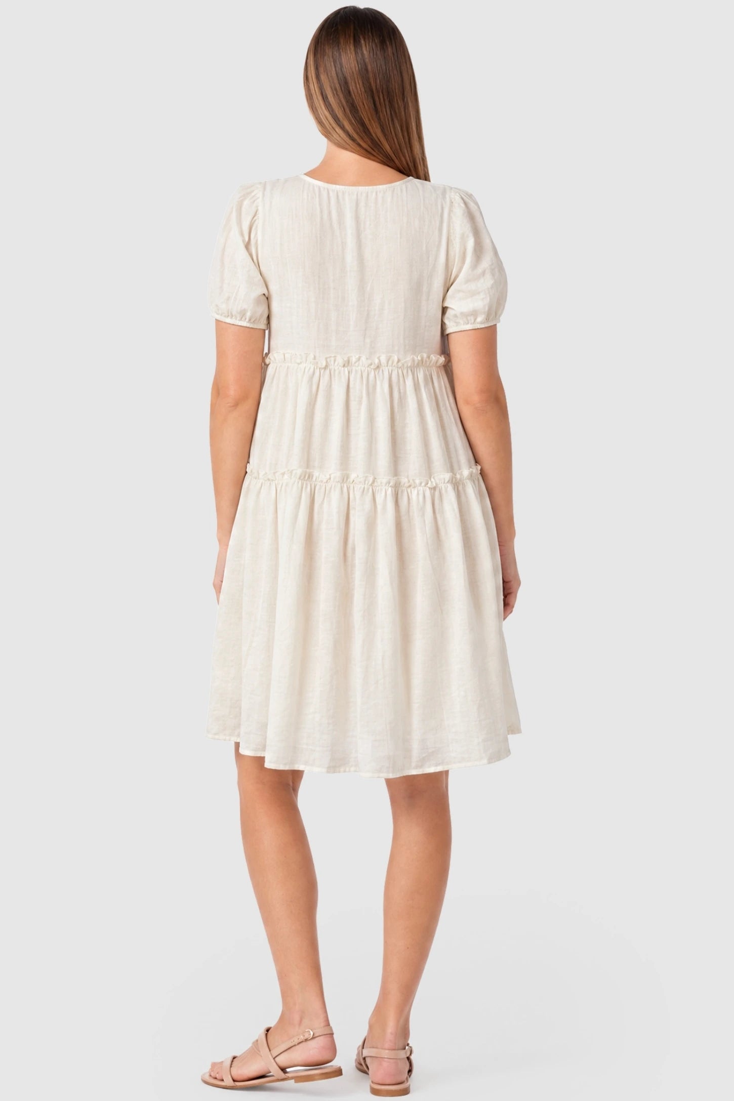 Puff Sleeve Tiered Midi Maternity Dress  Puff Sleeve Tiered Midi Maternity Dress in Off-White featuring ruffled tiered skirt on a pregnant model, back view.