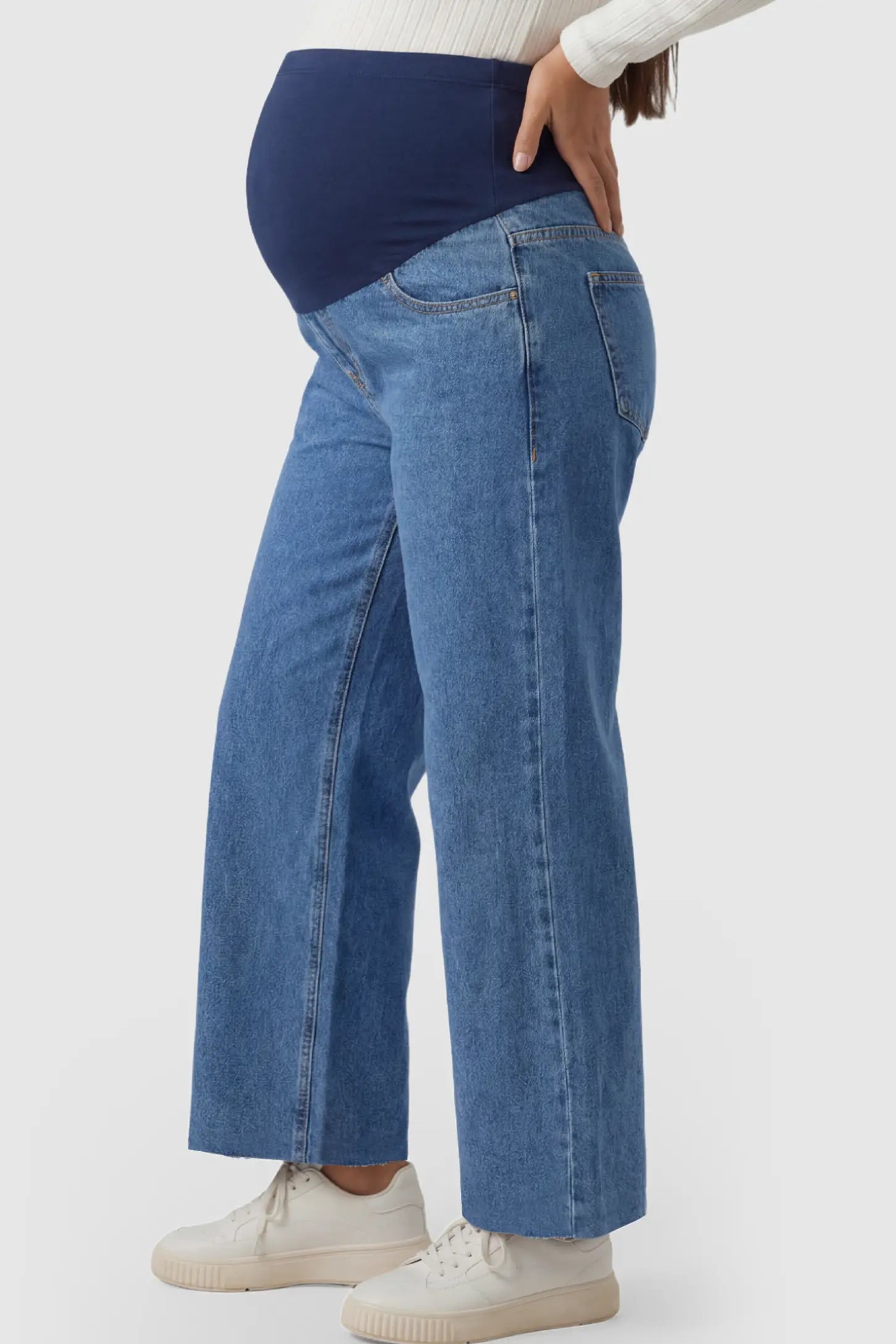 Raw Hem Full Panel Wide Leg Maternity Jeans Raw Hem Full Panel Wide Leg Maternity Jeans in dark blue featuring a high-rise navy belly band on a pregnant model showing side.