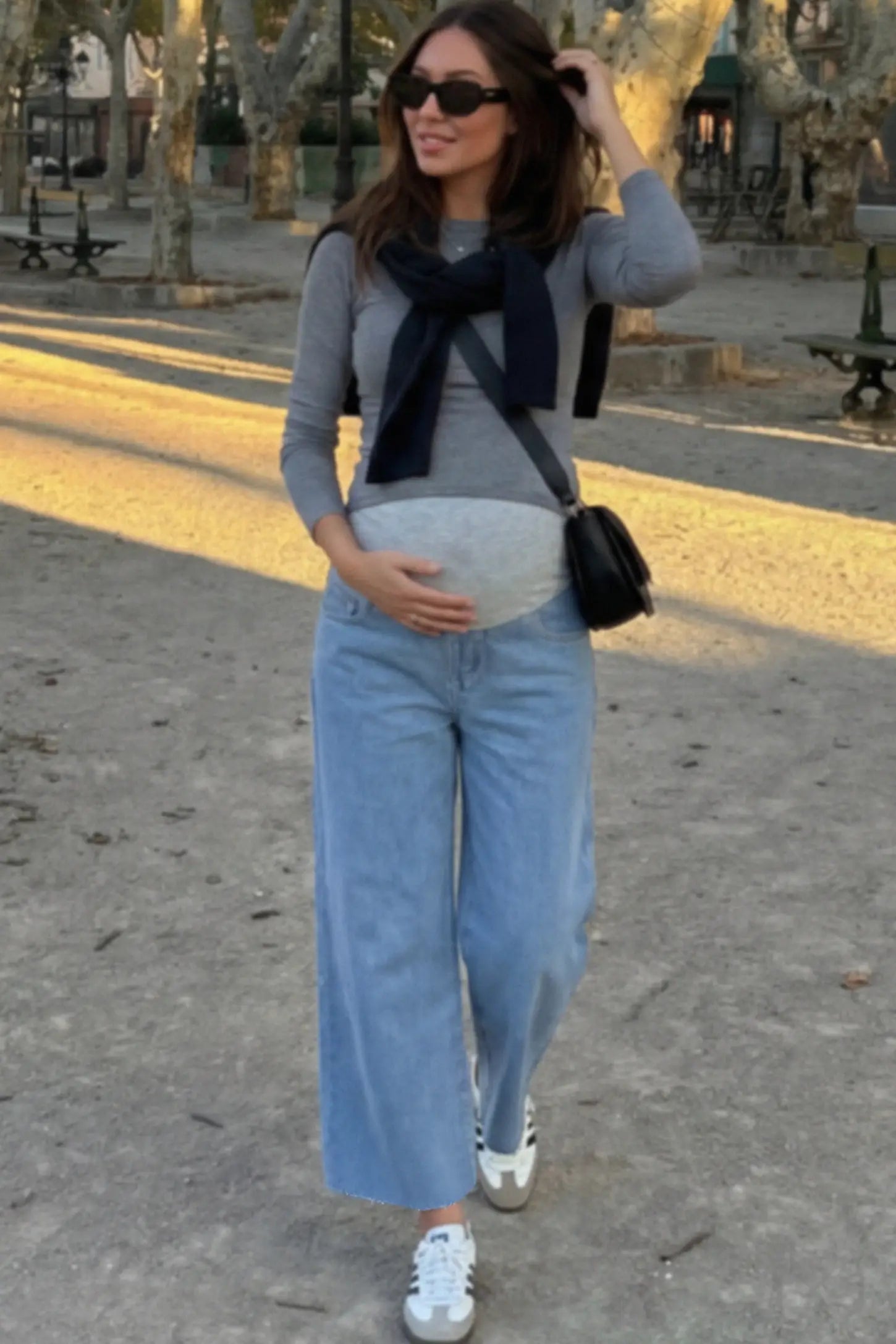 Raw Hem Full Panel Wide Leg Maternity Jeans Raw Hem Full Panel Wide Leg Maternity Jeans in light blue featuring a high-rise navy belly band on a pregnant woman.