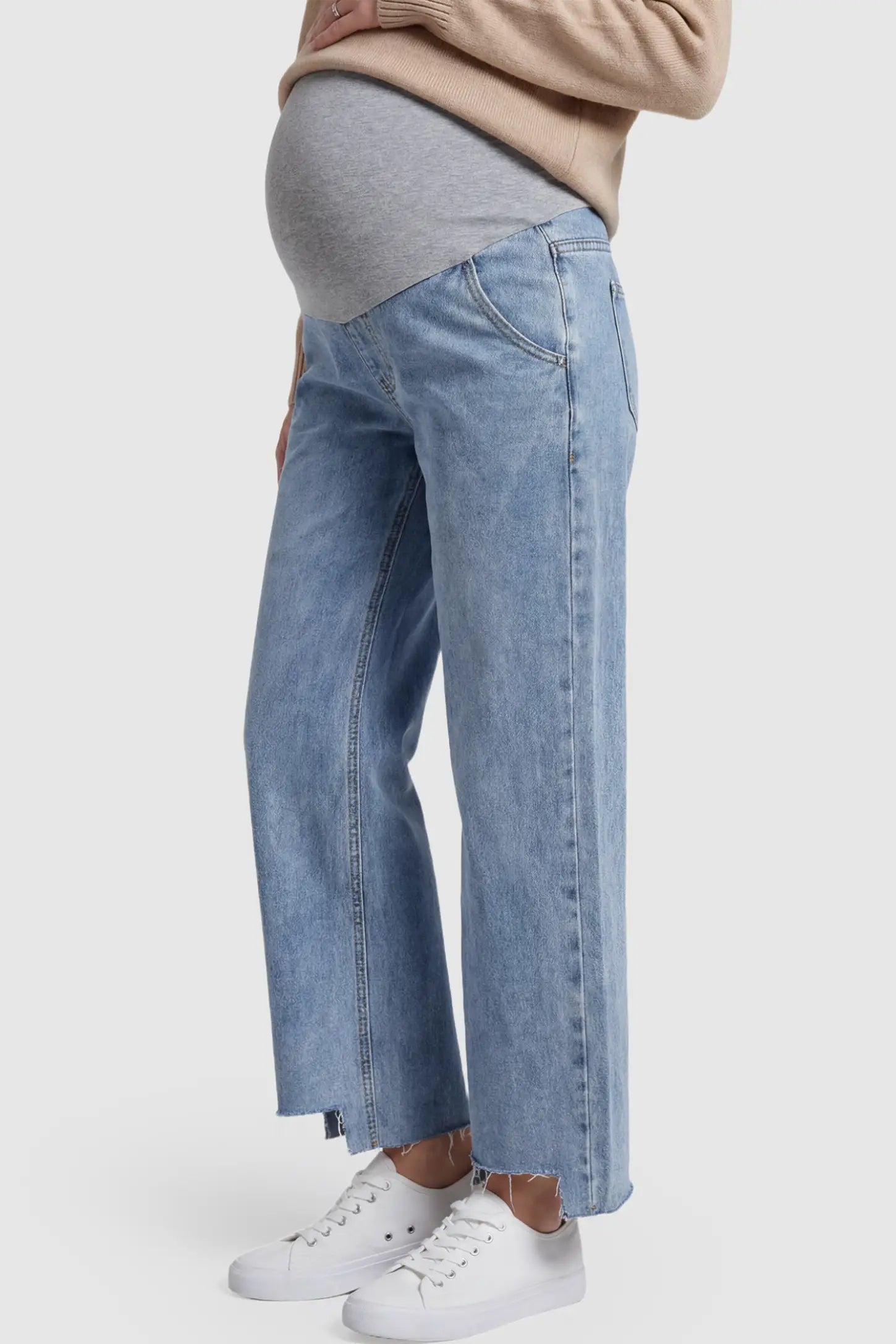 Raw Hem Wide Leg Maternity Jeans Raw Hem Wide Leg Maternity Jeans in Light Blue Denim with a grey over-the-belly comfort panel and raw hem on a pregnant model showing side.