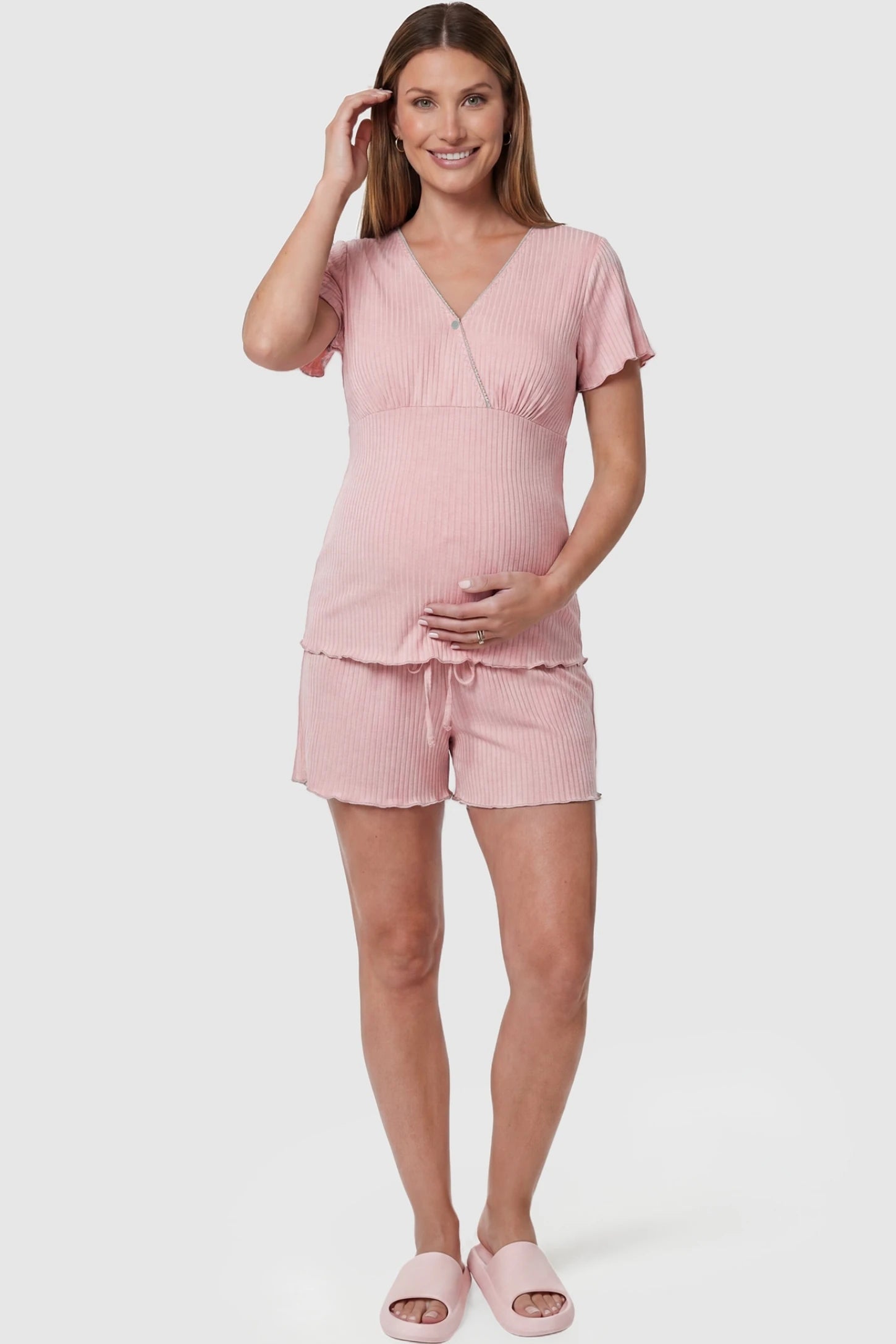 Ribbed Short Sleeve & Drawstring Shorts Maternity Pajama Set Ribbed Short Sleeve & Drawstring Shorts Maternity Pajama Set in Pink featuring a flattering empire seam on a pregnant model, front view.