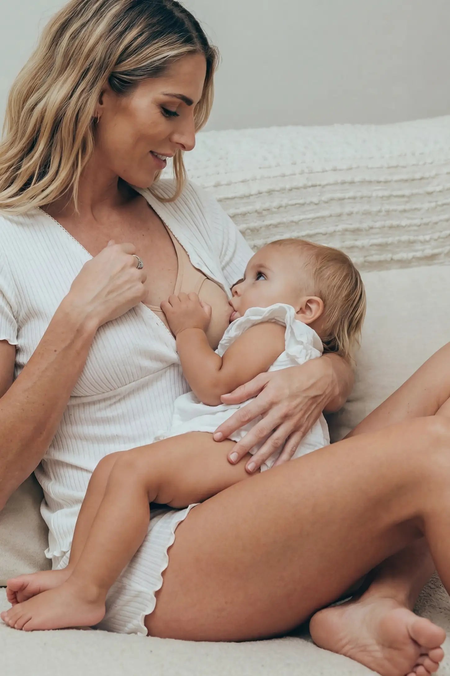 Ribbed Short Sleeve & Drawstring Shorts Maternity Pajama Set Ribbed Short Sleeve & Drawstring Shorts Maternity Pajama Set in White featuring a tender seated nursing moment with a child on a non-pregnant model, editorial lifestyle view.