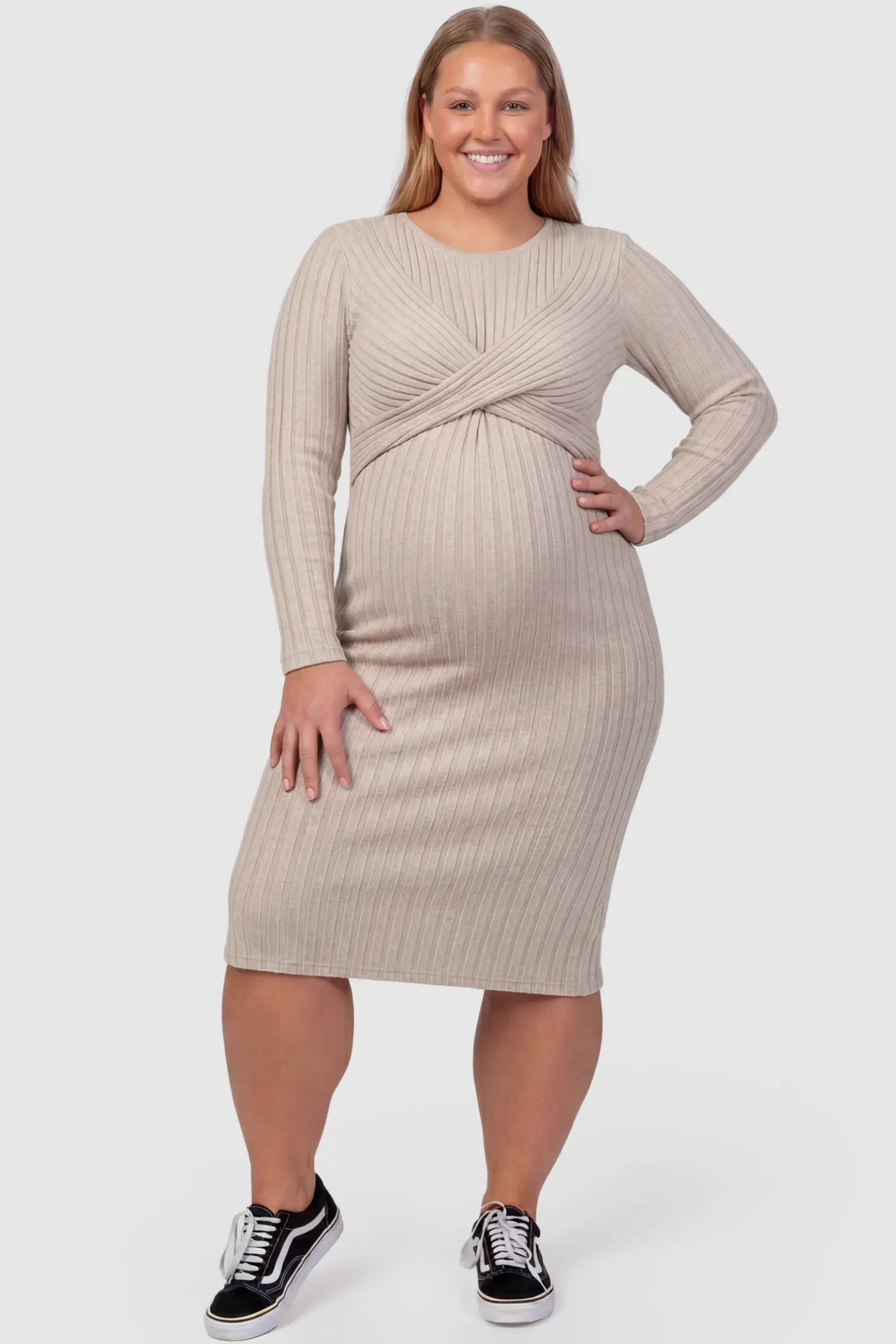Ribbed Knit Cross Front Fitted Maternity Midi Dress Ribbed Knit Cross Front Fitted Maternity Midi Dress in Apricot featuring a supportive criss-cross bodice on a plus size pregnant model, front view.