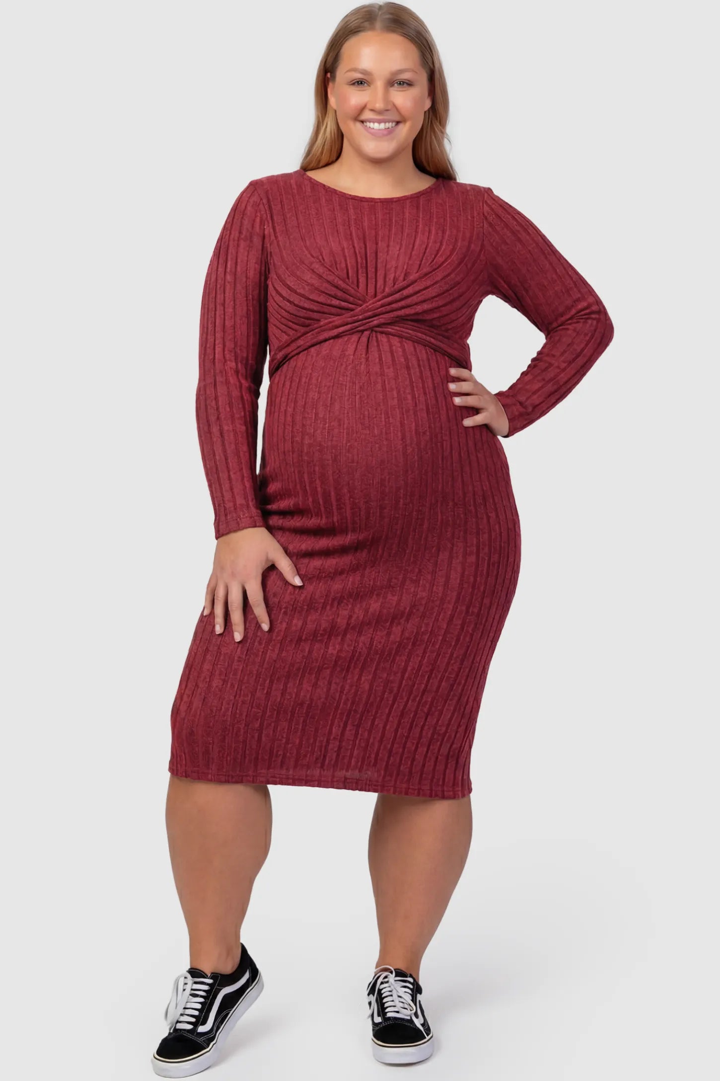 Ribbed Knit Cross Front Fitted Maternity Midi Dress Ribbed Knit Cross Front Fitted Maternity Midi Dress in Wine Red featuring a supportive criss-cross bodice on a plus size pregnant model, front view.