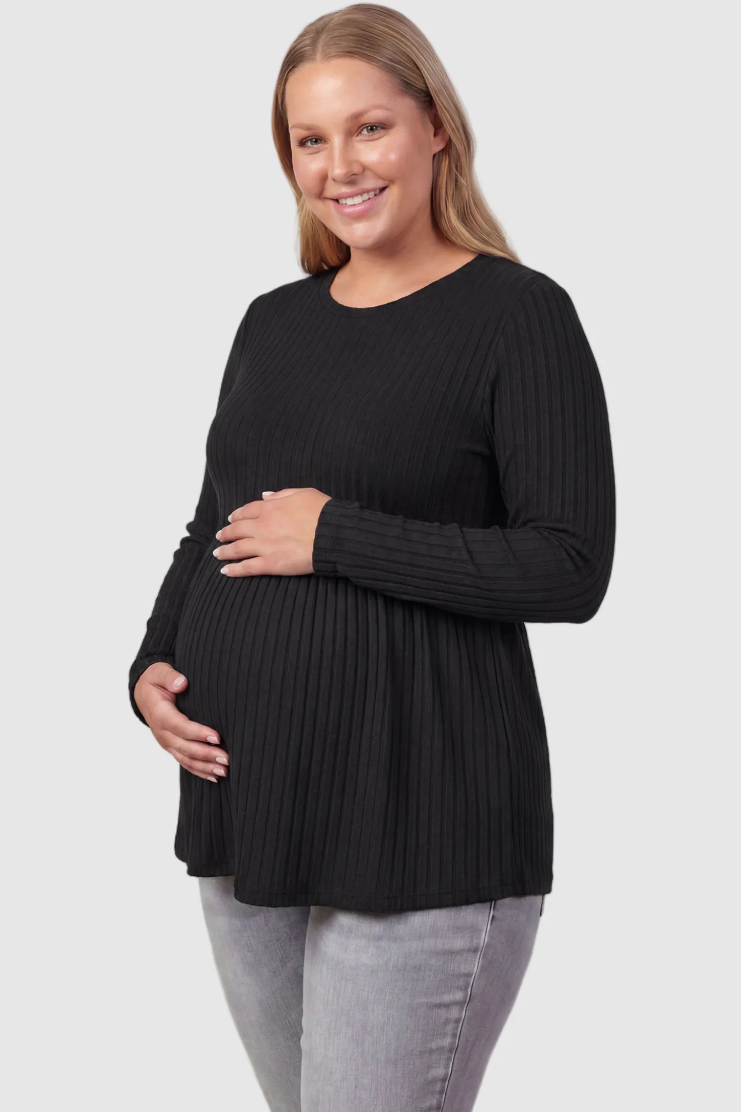 Ribbed Knit Long Sleeve Maternity Top Ribbed Knit Long Sleeve Maternity Top in Black featuring an empire waist and high-stretch fabric on a plus size pregnant model, front view.