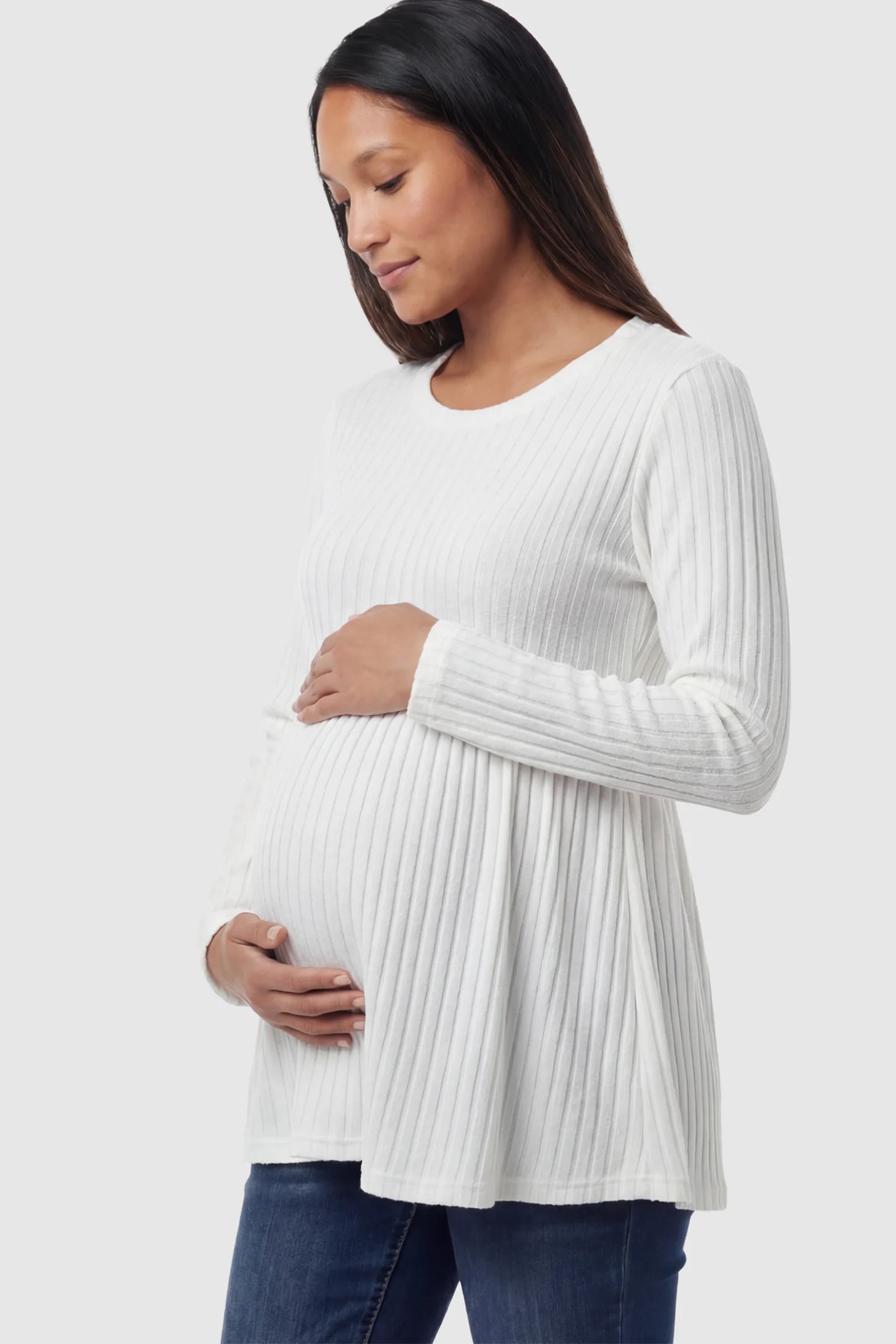 Ribbed Knit Long Sleeve Maternity Top Ribbed Knit Long Sleeve Maternity Top in White featuring an empire waist and high-stretch fabric on a pregnant model showing side.