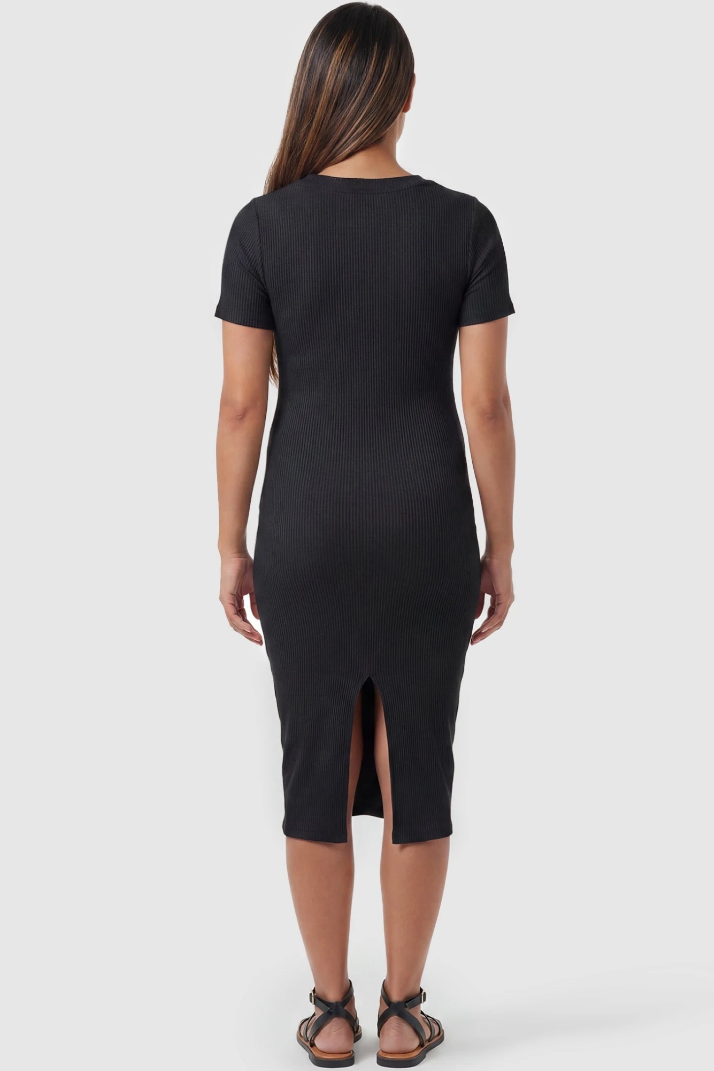 Ribbed Knit Short Sleeve Midi Maternity Dress Ribbed Knit Short Sleeve Midi Maternity Dress in Black featuring a center back slit on a pregnant model, back view.