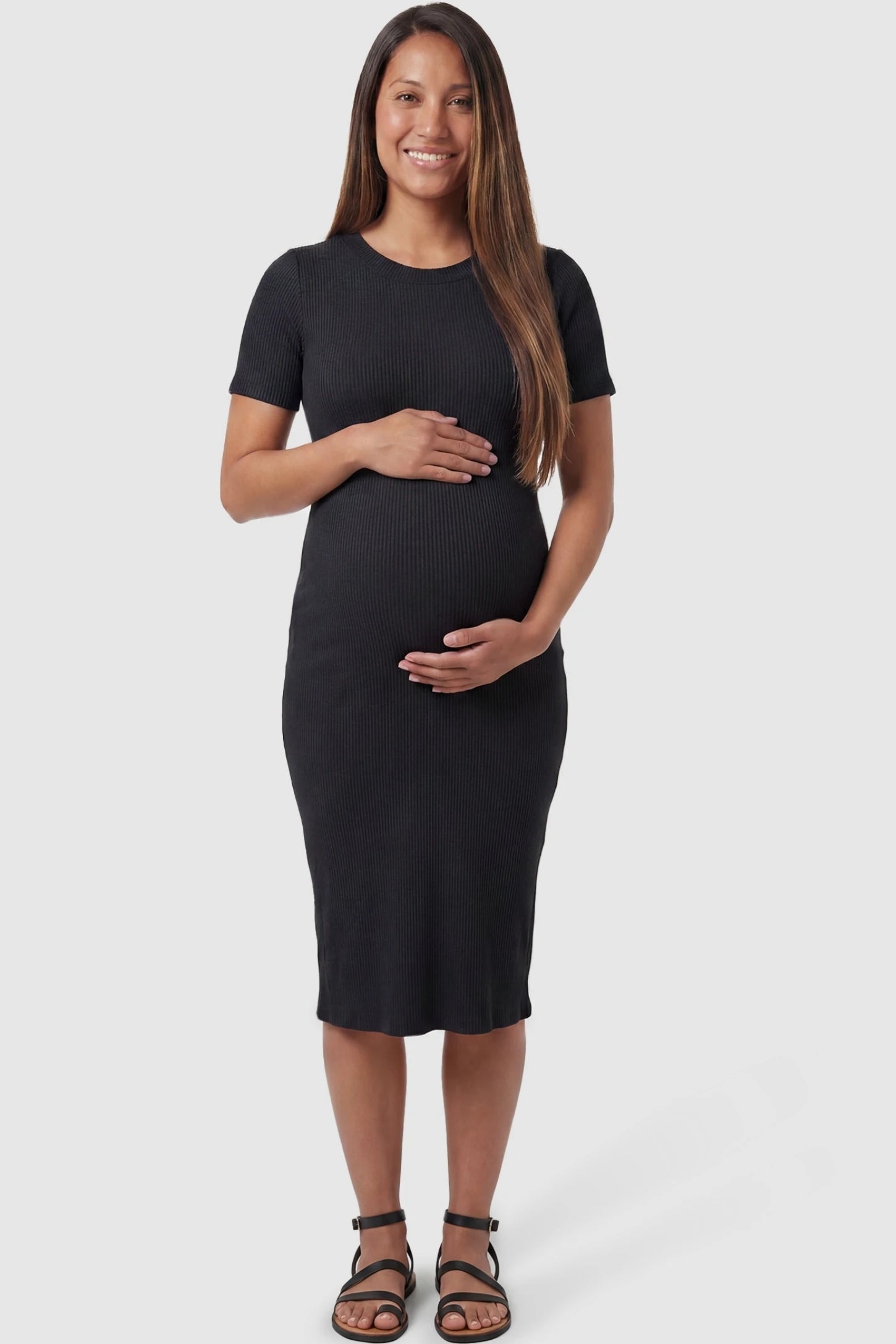 Ribbed Knit Short Sleeve Midi Maternity Dress Ribbed Knit Short Sleeve Midi Maternity Dress in Black featuring a form-fitting ribbed knit fabric on a pregnant model, front view.