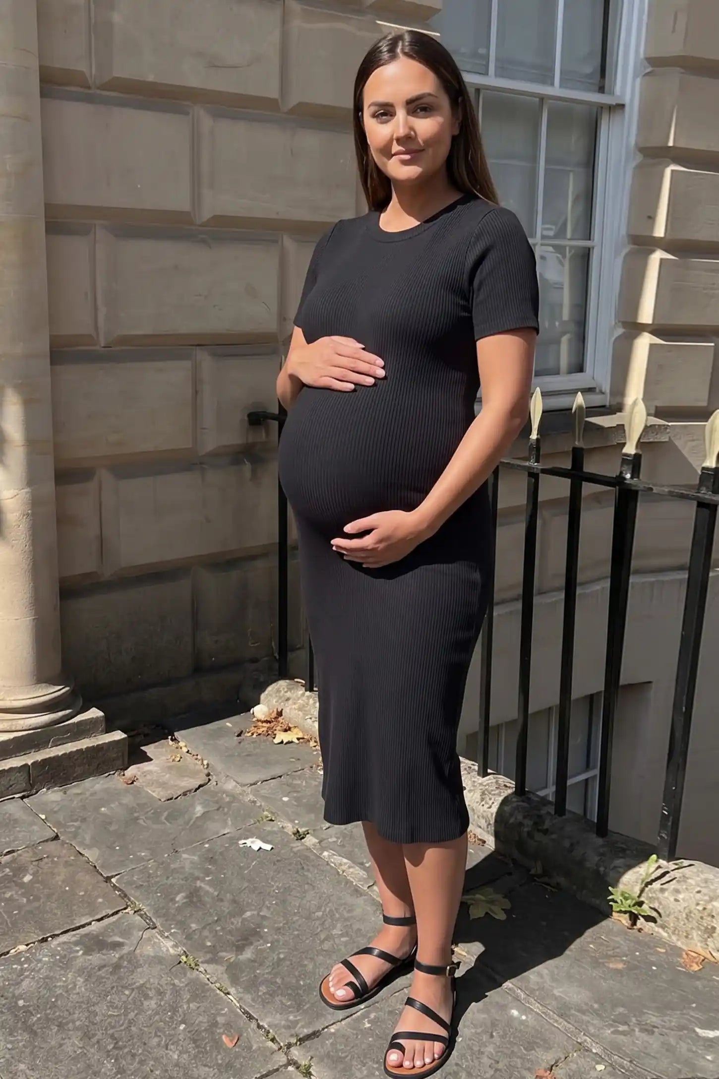 Ribbed Knit Short Sleeve Midi Maternity Dress Ribbed Knit Short Sleeve Midi Maternity Dress in Black featuring a sleek crew neckline worn by a pregnant model in an outdoor lifestyle photo.