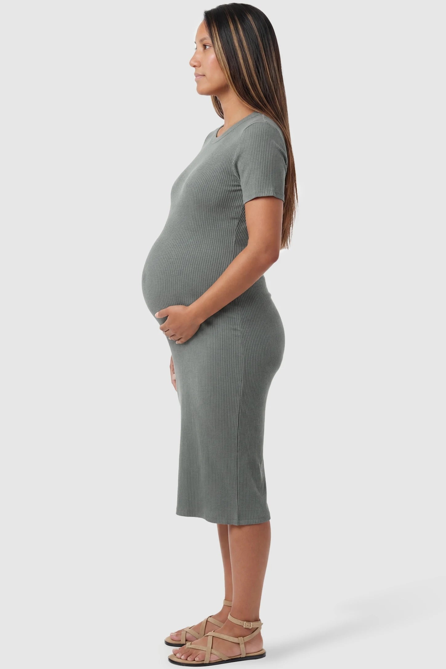 Ribbed Knit Short Sleeve Midi Maternity Dress Ribbed Knit Short Sleeve Midi Maternity Dress in Green featuring a form-fitting silhouette on a pregnant model, side view.