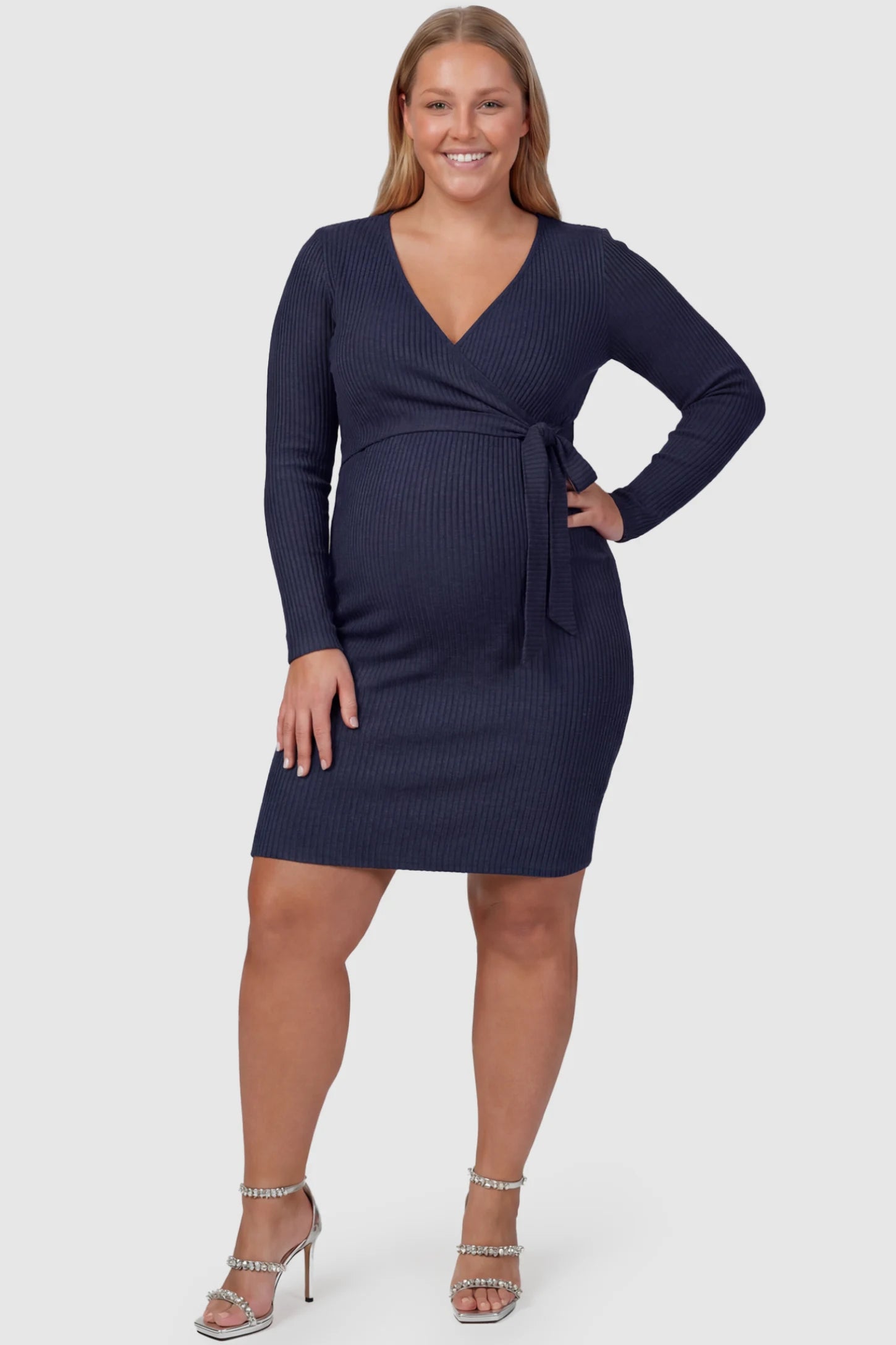 Ribbed Knit Wrap-Front Long Sleeve Maternity & Nursing Dress Ribbed Knit Wrap-Front Long Sleeve Maternity & Nursing Dress in Dark Blue featuring functional wrap bodice on a plus size pregnant model, front view.