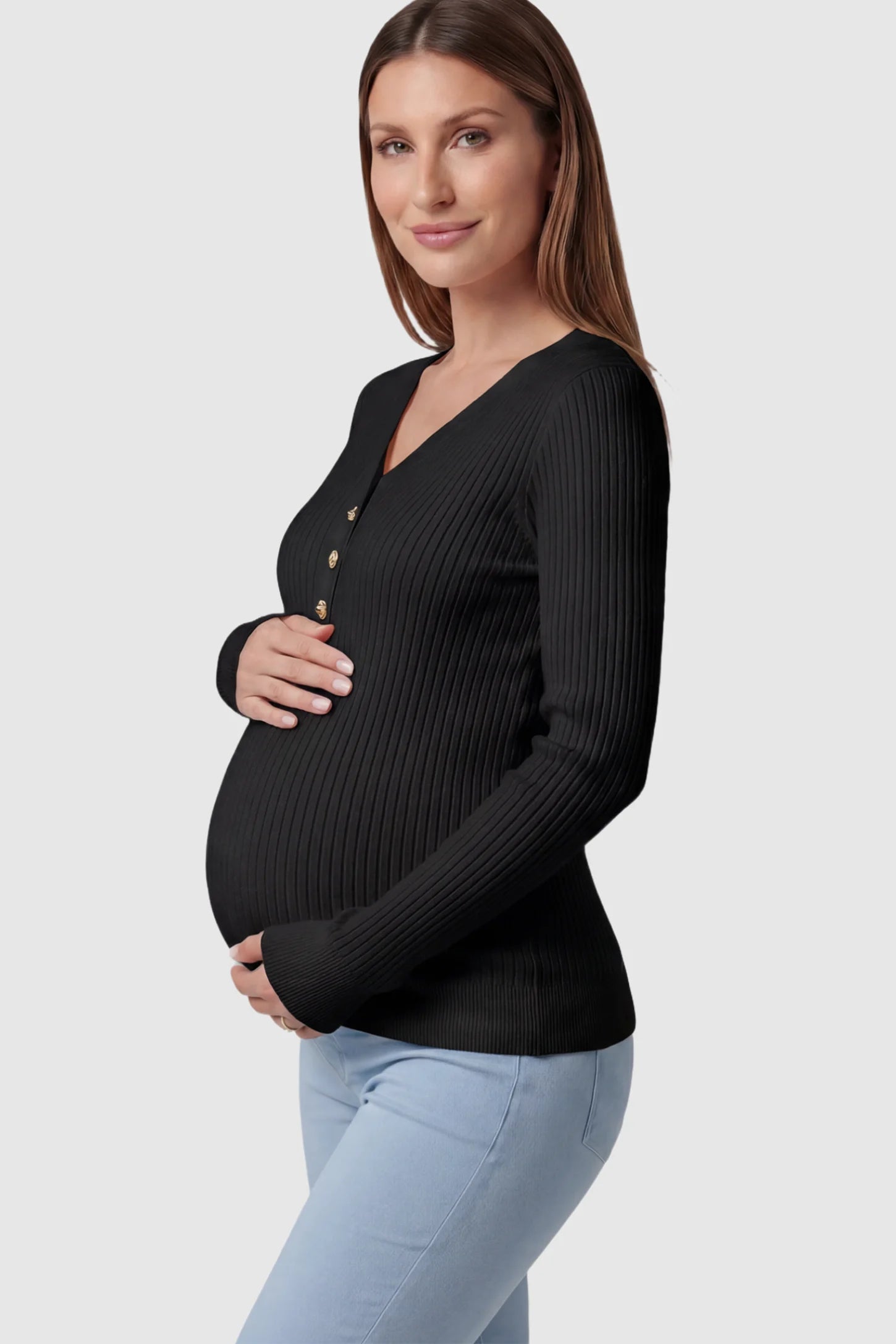 Ribbed Long Sleeve Maternity Henley Top Ribbed Maternity Henley Top in Black featuring a functional button placket and vertical rib knit on a pregnant model showing side.